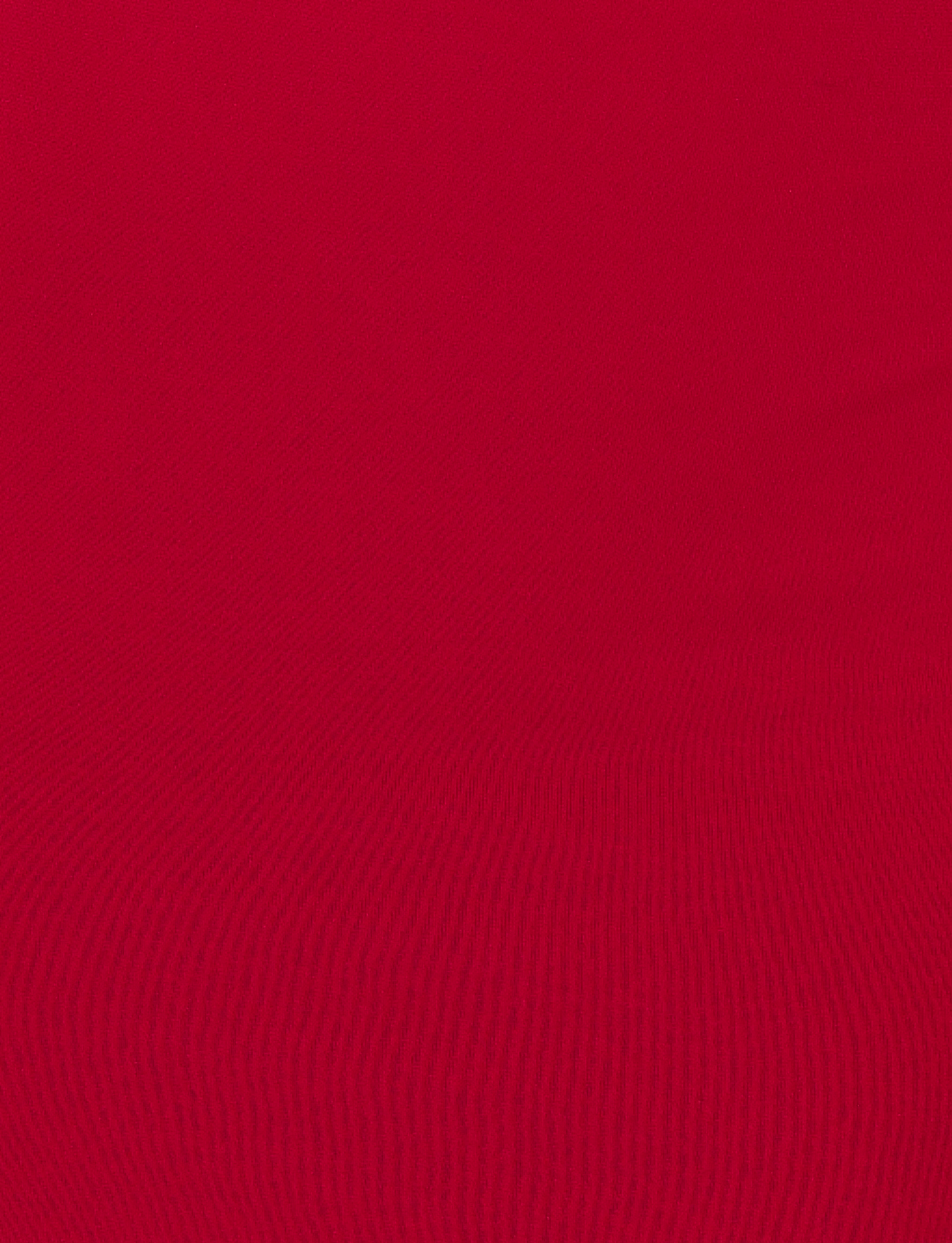 A close-up of red, textured fabric with subtle horizontal ridges, similar to the material used in the TIGERMIST MORANA MAXI DRESS - RED.