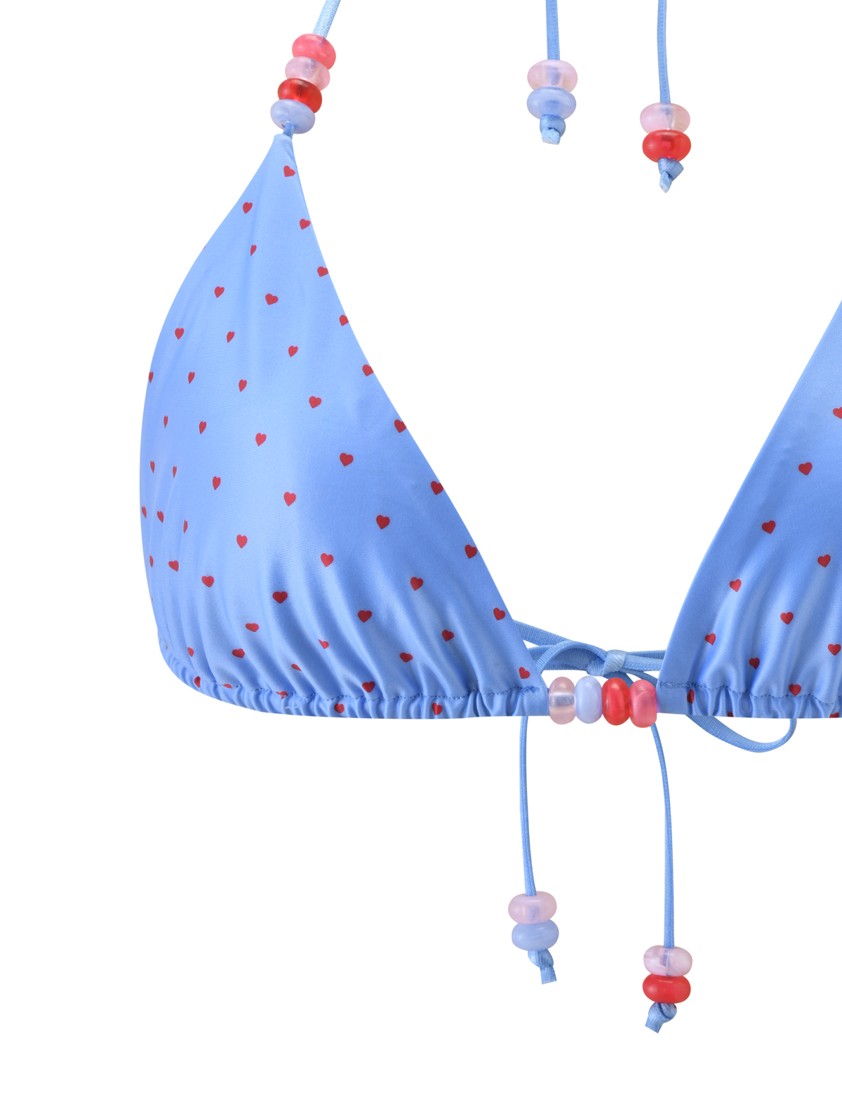 Close-up of the FINLEA BIKINI TOP - BLUE HEART POLKA DOT by TIGERMIST, a light blue triangle bikini top with red heart polka dots and adjustable halter neck strings decorated with pink, red, and purple beads. Plain white background.