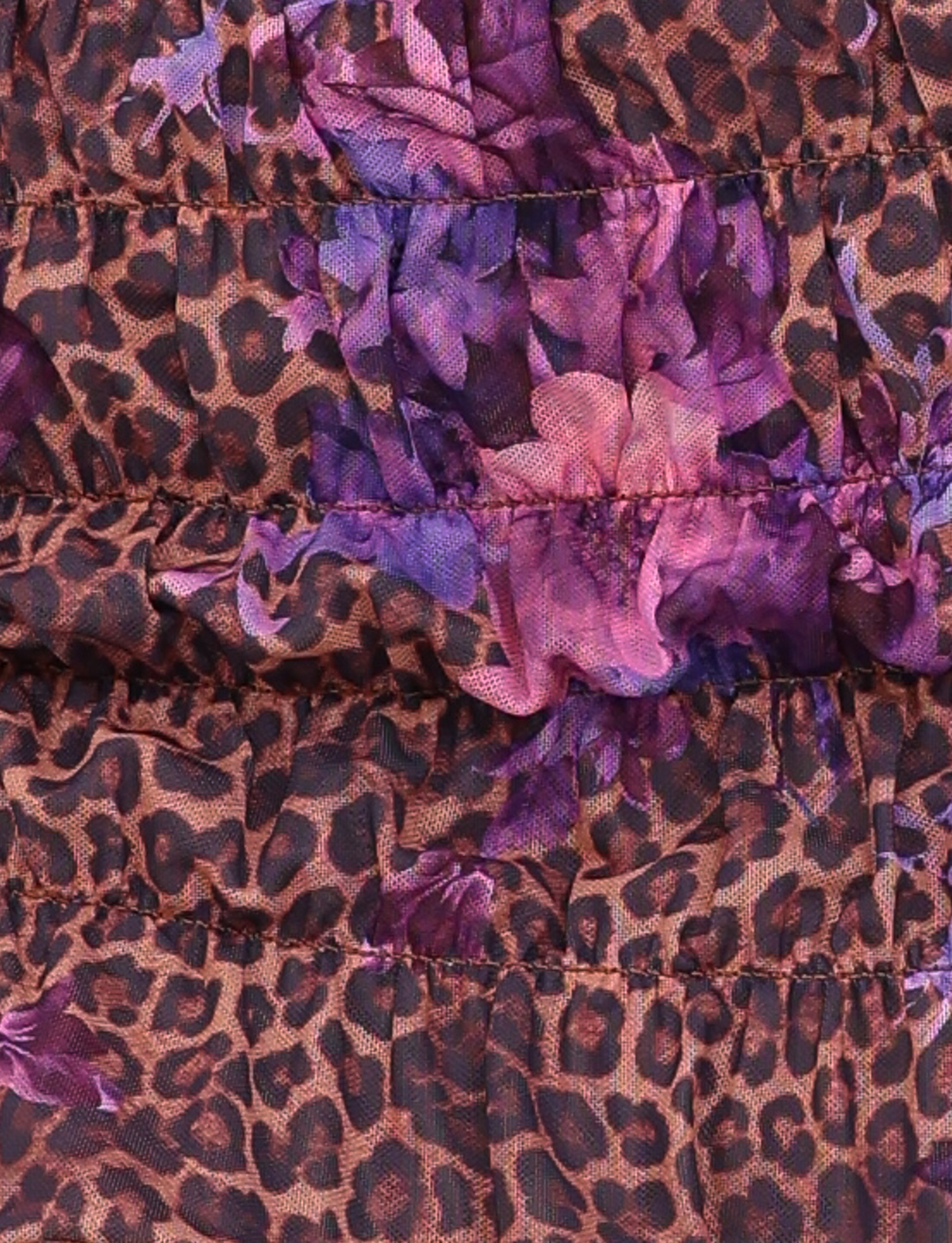 Close-up of the TIGERMIST HOLLIS SKORT in Neutral Floral Leopard, featuring brown and black leopard print with purple and pink floral overlays, visible seams, and gathered stitching.