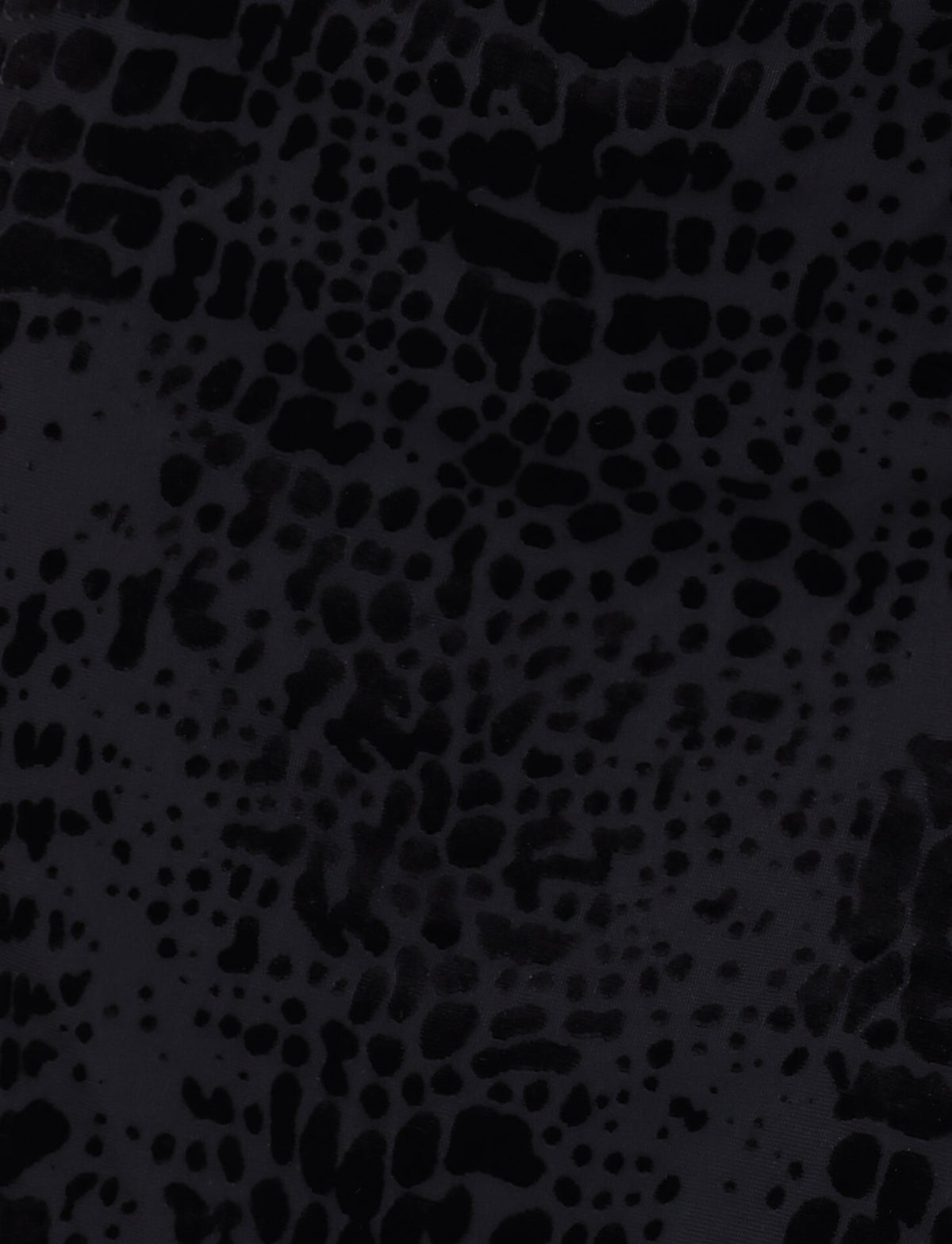 The ALLIRA BURNOUT MINI DRESS 2.0 by TIGERMIST features a black surface with an abstract pattern of irregular, splotchy dark spots that resemble an animal print or a textured material, evoking the look of a velvet burnout design akin to a snake pattern.