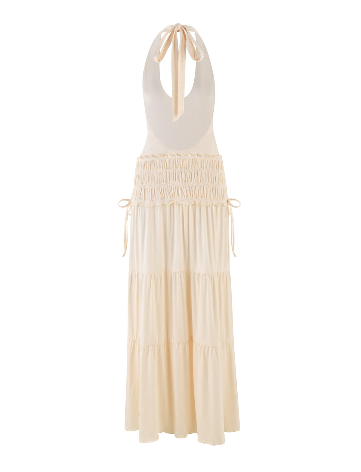 The DENALI HALTER DRESS - NEUTRAL : BONE by TIGERMIST is a sleeveless maxi dress featuring a halter tie-back neck, deep open back, ruched waist, side ties, and a tiered flowing skirt in a cream bone shade.
