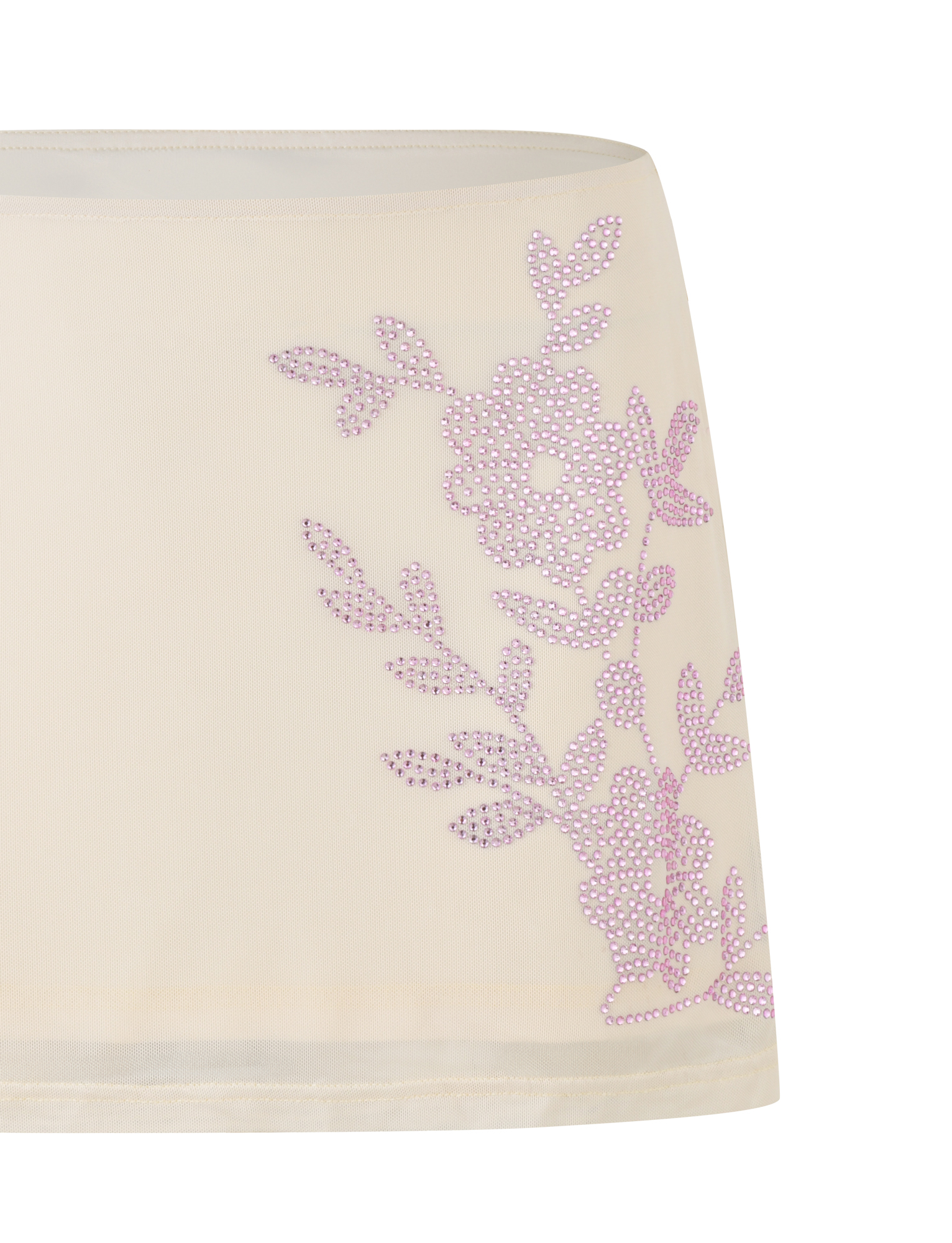 The OCTAVIA MINI SKIRT - NEUTRAL : CREAM by TIGERMIST is a sheer, cream mini skirt with a rhinestone pink floral design on one side.