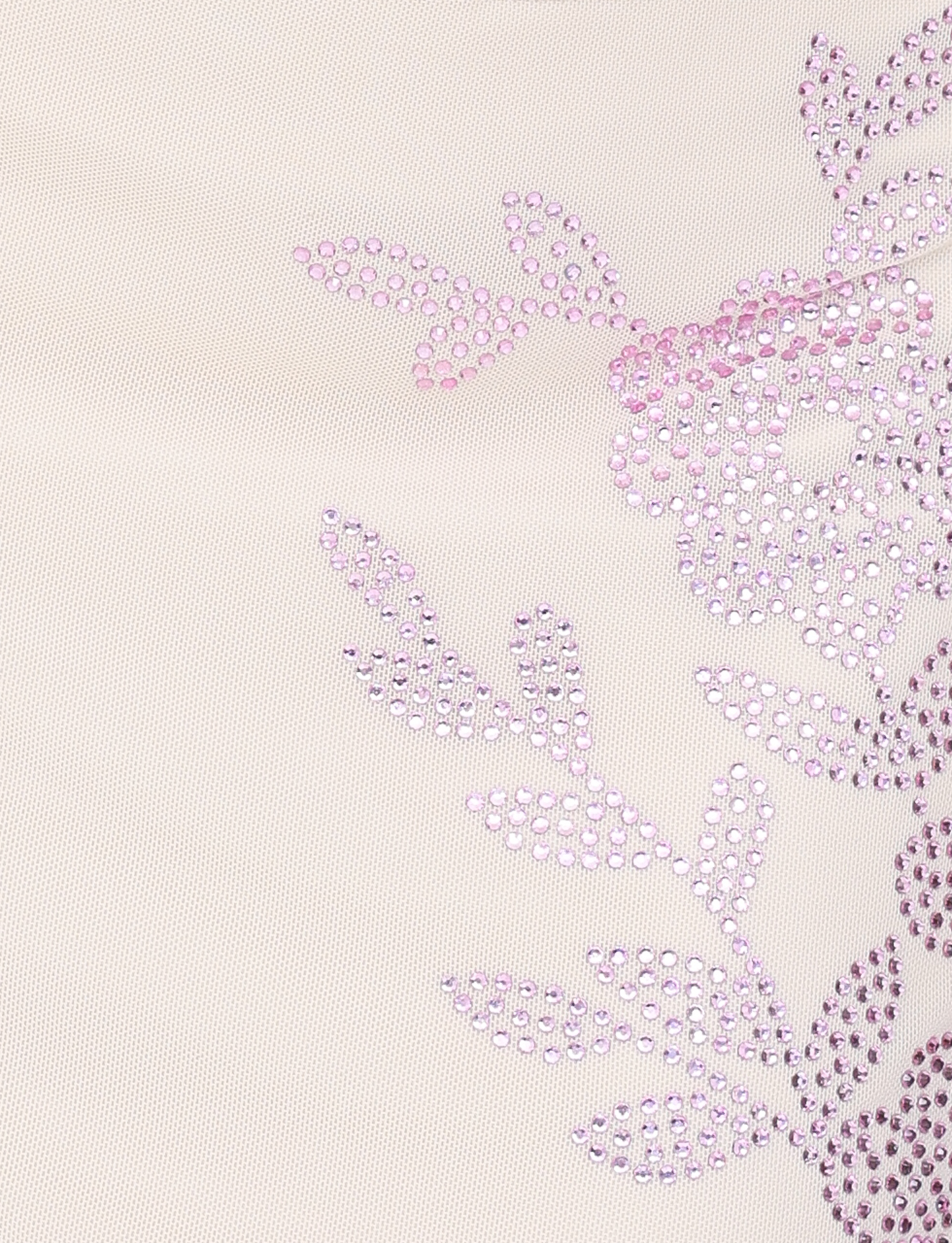 A close-up of the TIGERMIST OCTAVIA MINI SKIRT in cream, featuring light fabric with a floral pattern made from small, shiny pink rhinestones arranged as leaves and flowers on the right side.