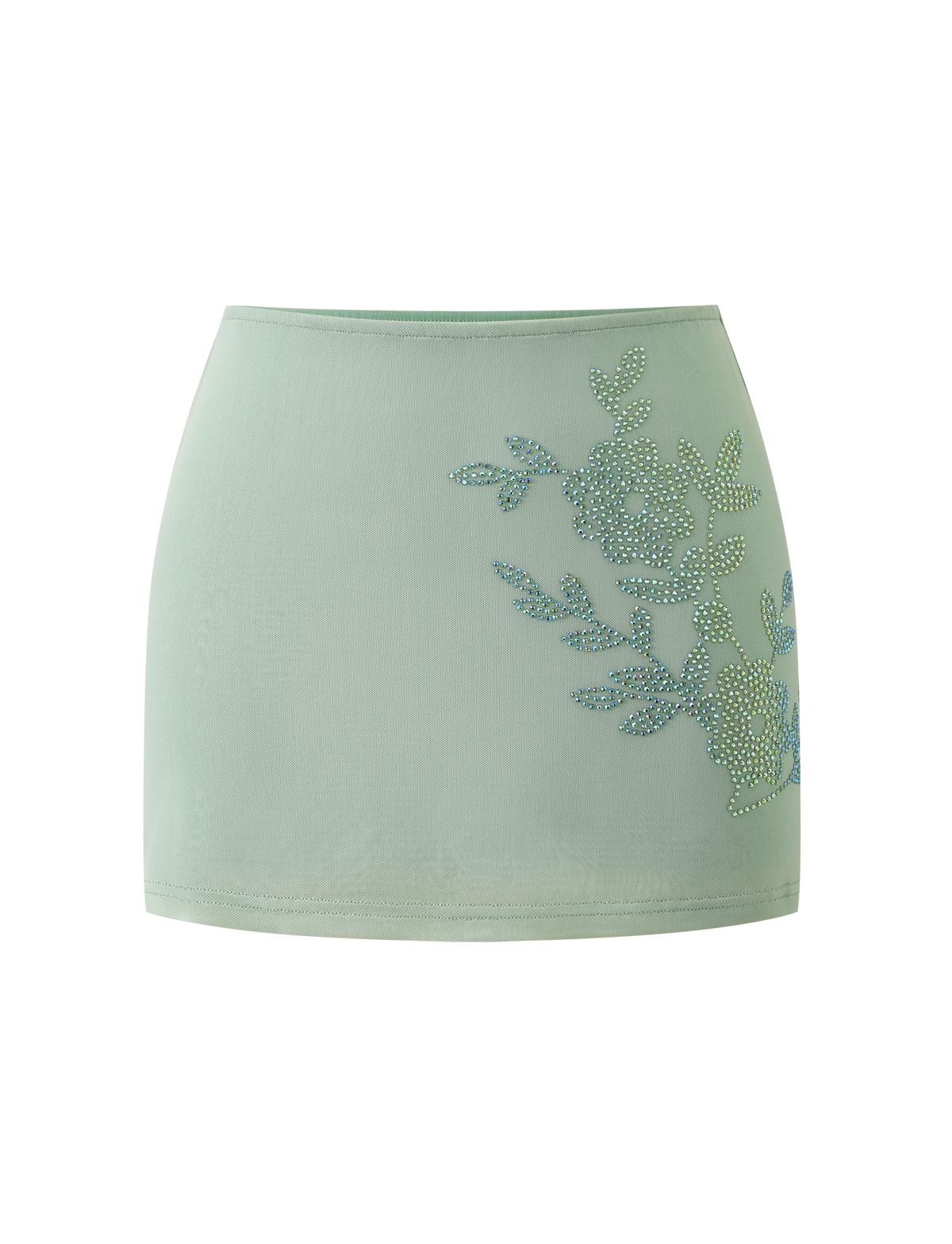 The OCTAVIA MINI SKIRT in pistachio by TIGERMIST features a light green hue and rhinestone floral embellishment on one side, showcased against a plain white background.