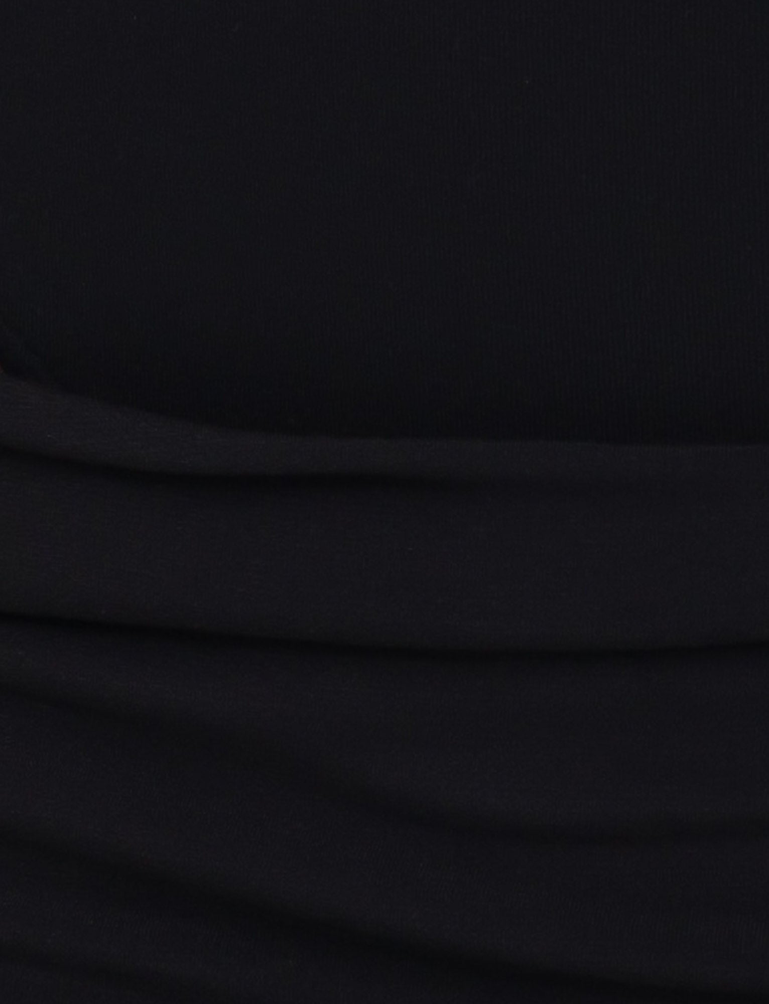 A close-up of the UMA DRESS - BLACK by TIGERMIST highlights its high stretch jersey fabric with gentle folds and horizontal wrinkles, giving it a soft, textured look.
