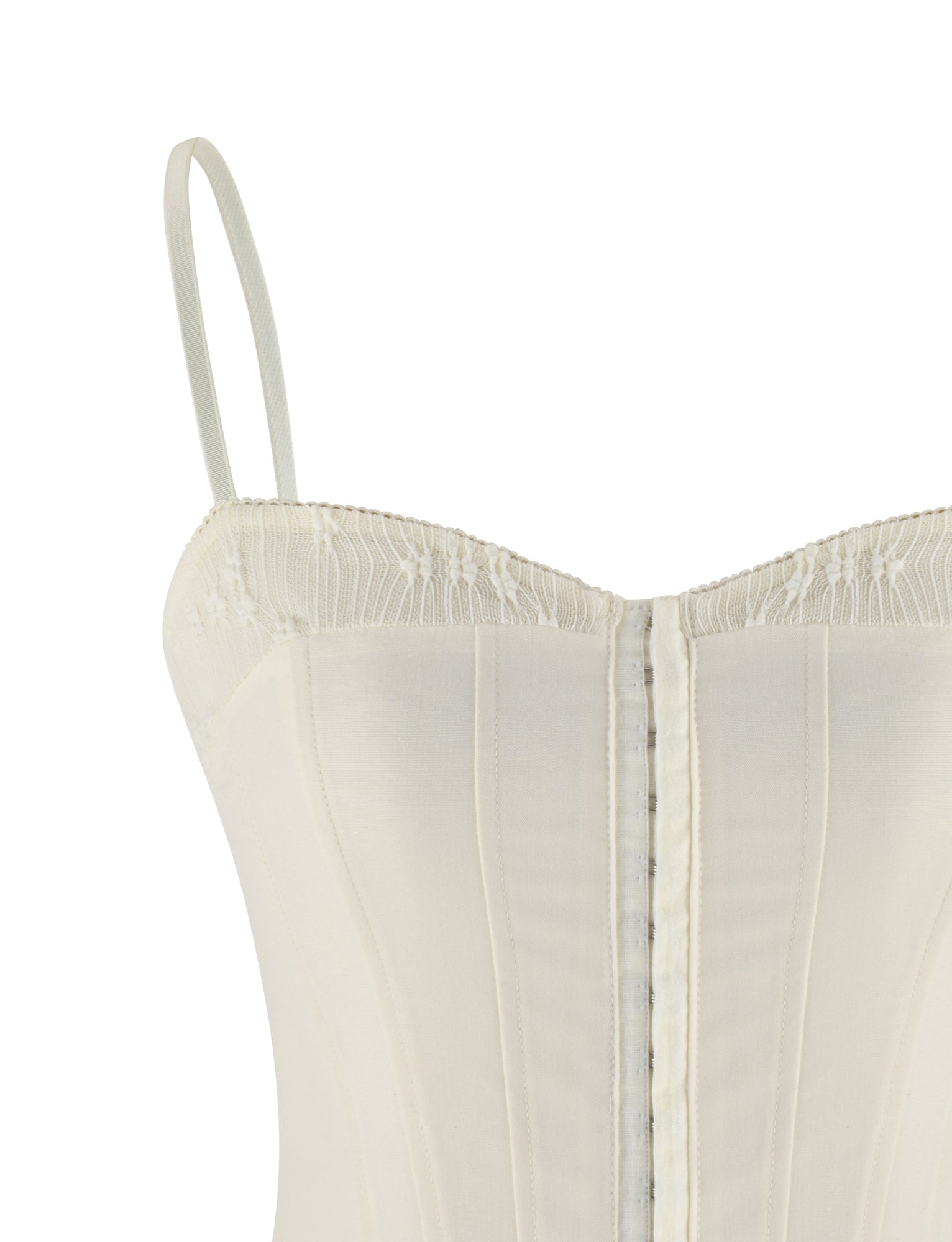 Close-up of the TIGERMIST ANTONELLA TOP in white, bone, and cream—an off-white corset style with spaghetti straps, vertical boning, lace-trimmed edge, and soft touch suiting fabric for comfort.