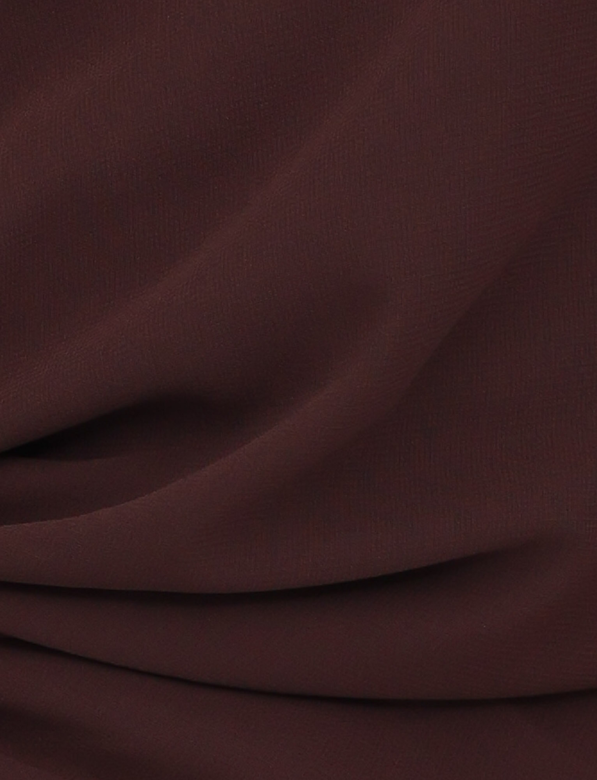 Close-up of the TIGERMIST INDIGO TOP - BROWN : CHOCOLATE shows chocolate brown fabric with soft folds and a textured surface, creating gentle shadows—ideal for a chic and elegant statement piece.