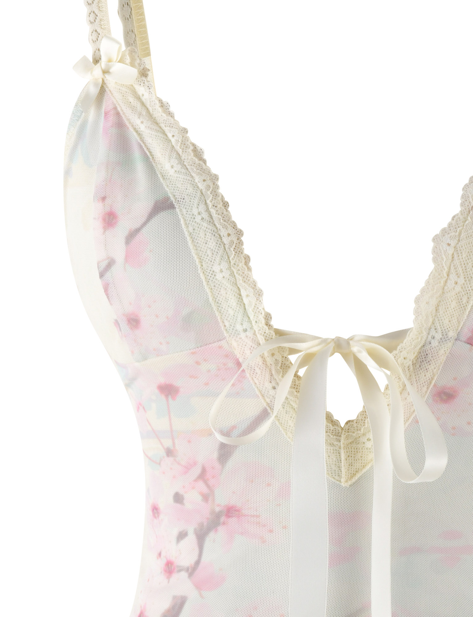 Close-up of the TIGERMIST LONIE TOP in a neutral floral washed cherry blossom print, featuring lace trim straps, satin bow accents, and soft pink and white hues.