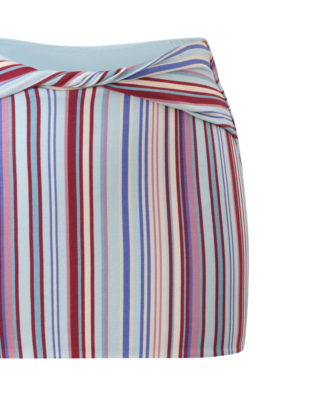 A close-up of the TIGERMIST HAZE TWIST SKIRT - VARIEGATED STRIPE, a fitted mini skirt featuring a diagonal waistband and vertical stripes in red, blue, white, and light pink on a light blue background.