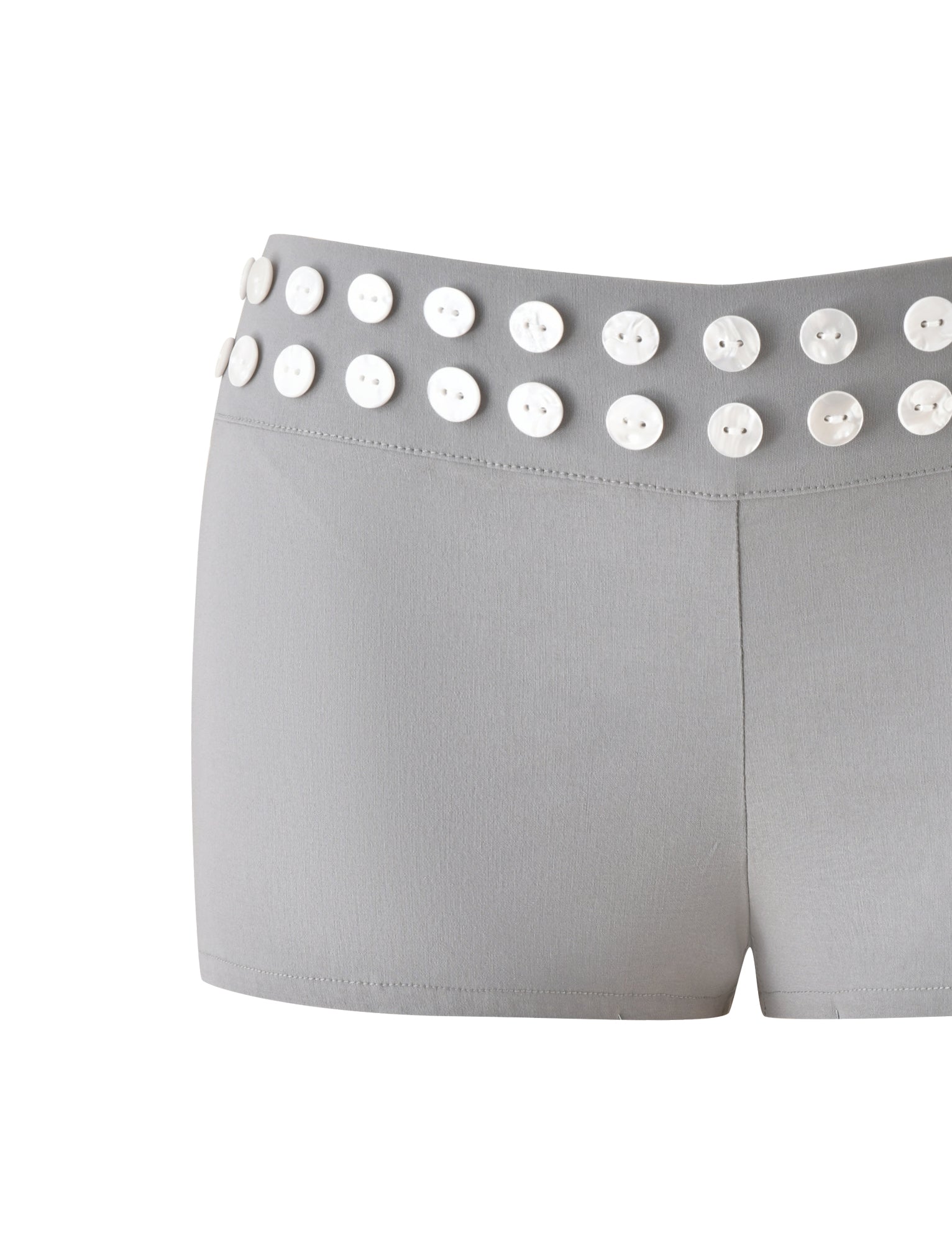 The SUKI SHORT - GREY by TIGERMIST features a tailored silhouette with a fitted style, crafted from smooth-textured fabric. The waistband is accented with two rows of evenly spaced white faux shell buttons for a distinctive touch.