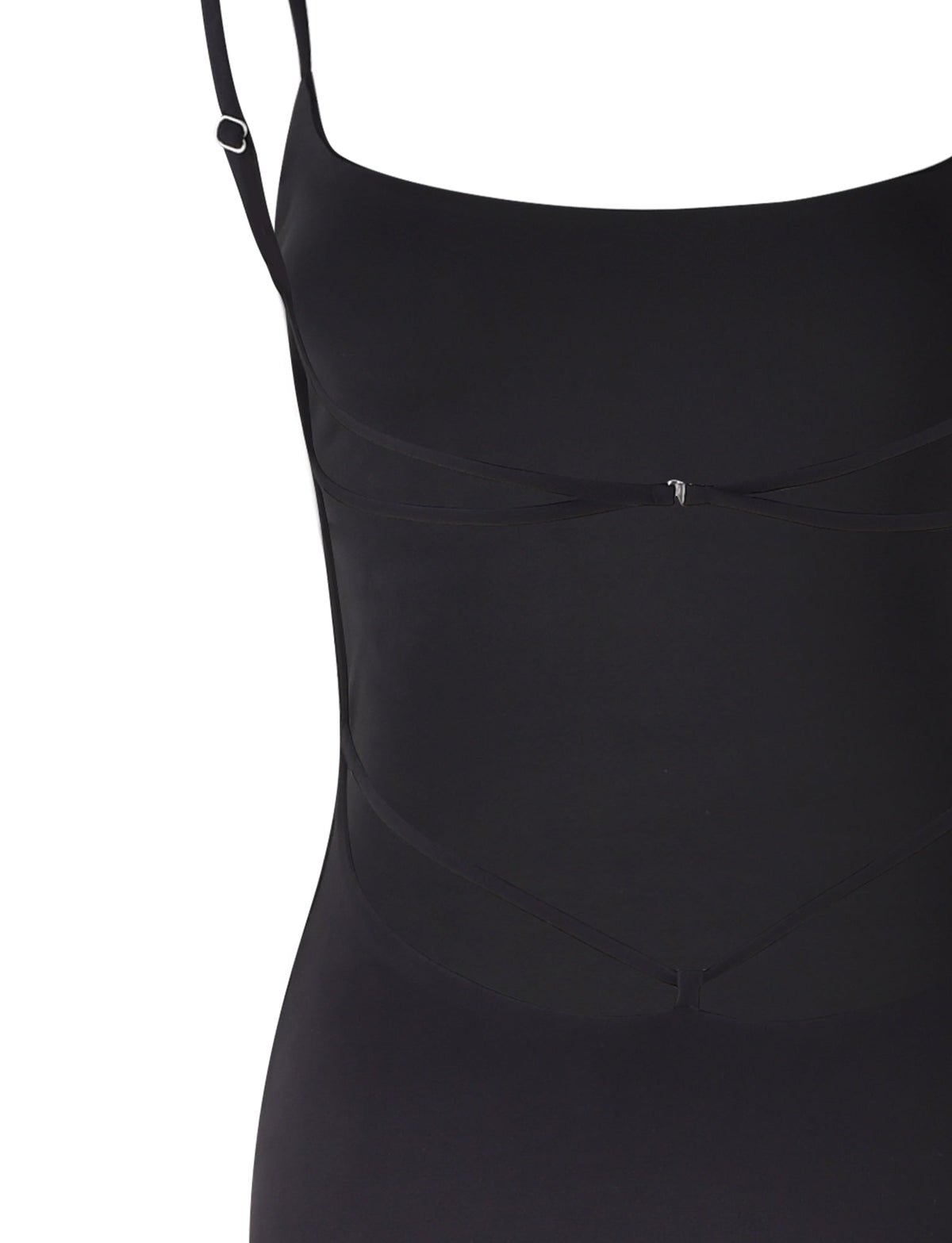 A close-up view of the MINERVA MAXI DRESS - BLACK from TIGERMIST. The top portion features thin shoulder straps and subtle black ribbon detailing near the bust area, designed to add a decorative touch. The fabric appears smooth and fitted, giving a sleek appearance.