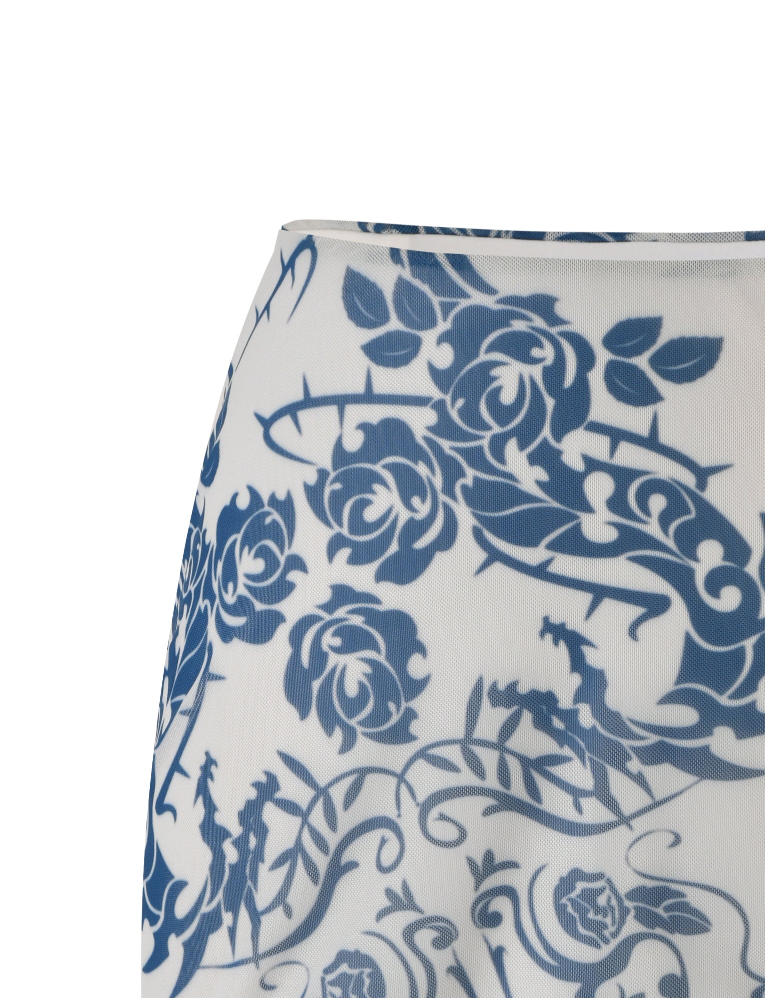 Close-up of the FINOLA MESH MINI SKIRT - BLUE : TATTOO : TATTOO PRINT from TIGERMIST, featuring an intricate blue floral and dragon pattern on a white background. The design showcases detailed flowers, leaves, and dragon figures, highlighting the delicate and elaborate artwork. The fabric appears lightweight and semi-transparent.
