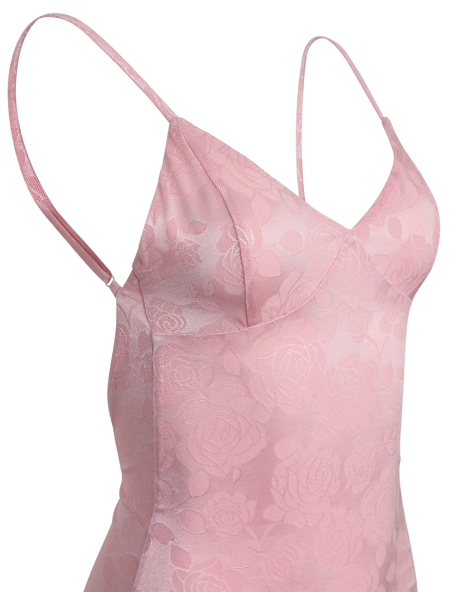A close-up view of the ERICKA DRESS - PINK from TIGERMIST showcases its sleeveless design and thin straps. The fabric features a subtle embroidered floral pattern that adds texture and elegance to the dress. The neckline is V-shaped, complemented by a fitted bodice.