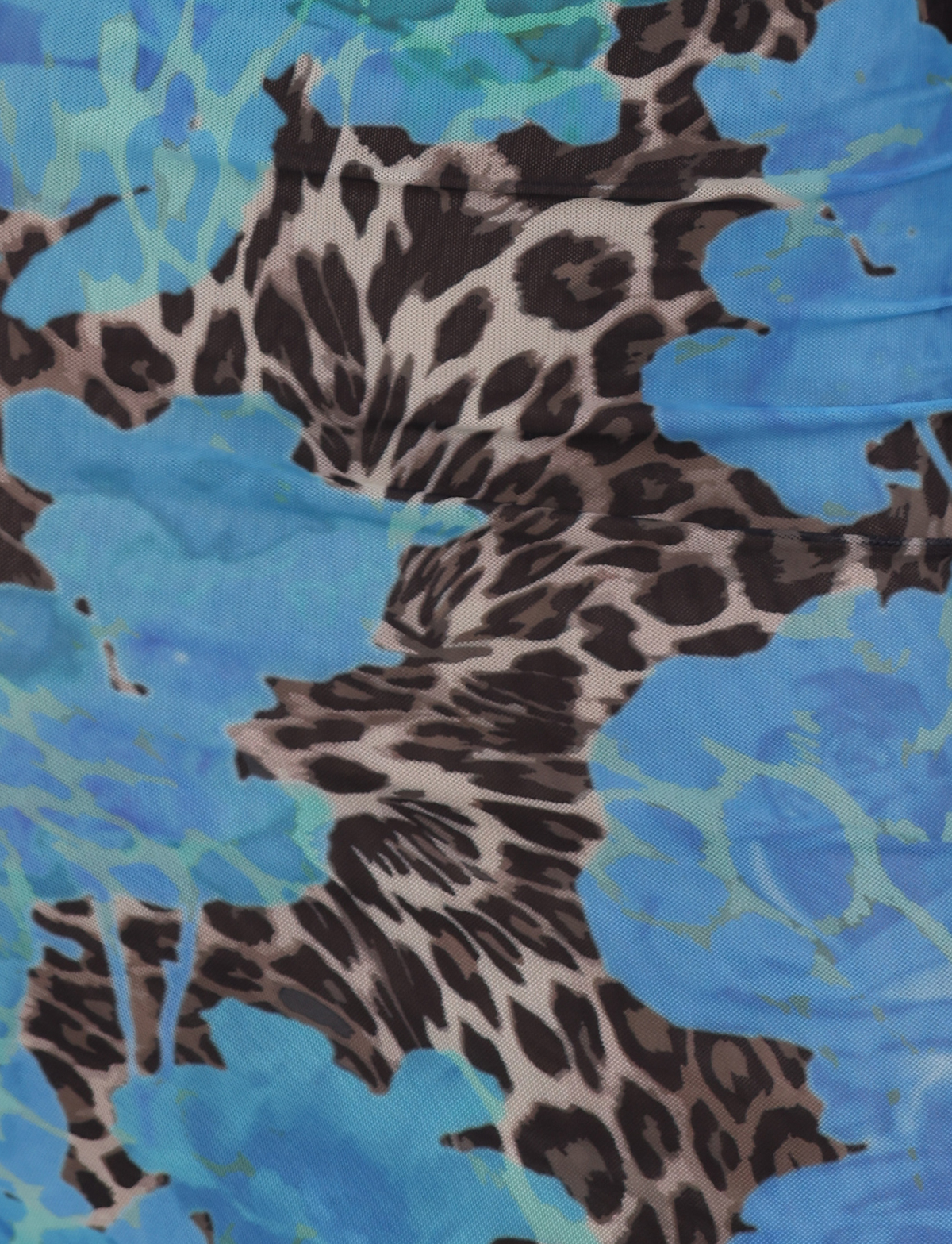 Close-up of TIGERMIST's JULIANNA DRESS - BLUE : LEOPARD, showcasing a vibrant fabric with blue floral and turquoise abstract shapes blended with black and brown leopard spots.