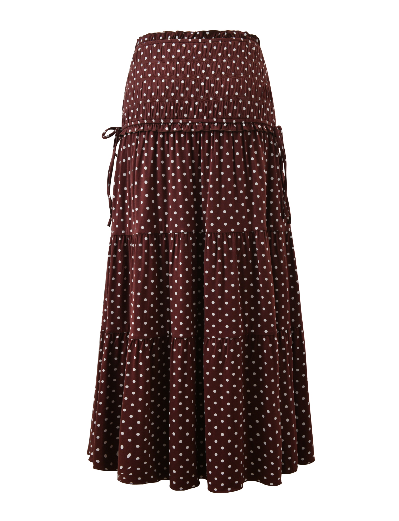 The DENALI MAXI SKIRT - BROWN DOT by TIGERMIST is an ankle-length, high-waisted tiered skirt in soft modal, featuring white polka dots and a matching tie belt at the waist.