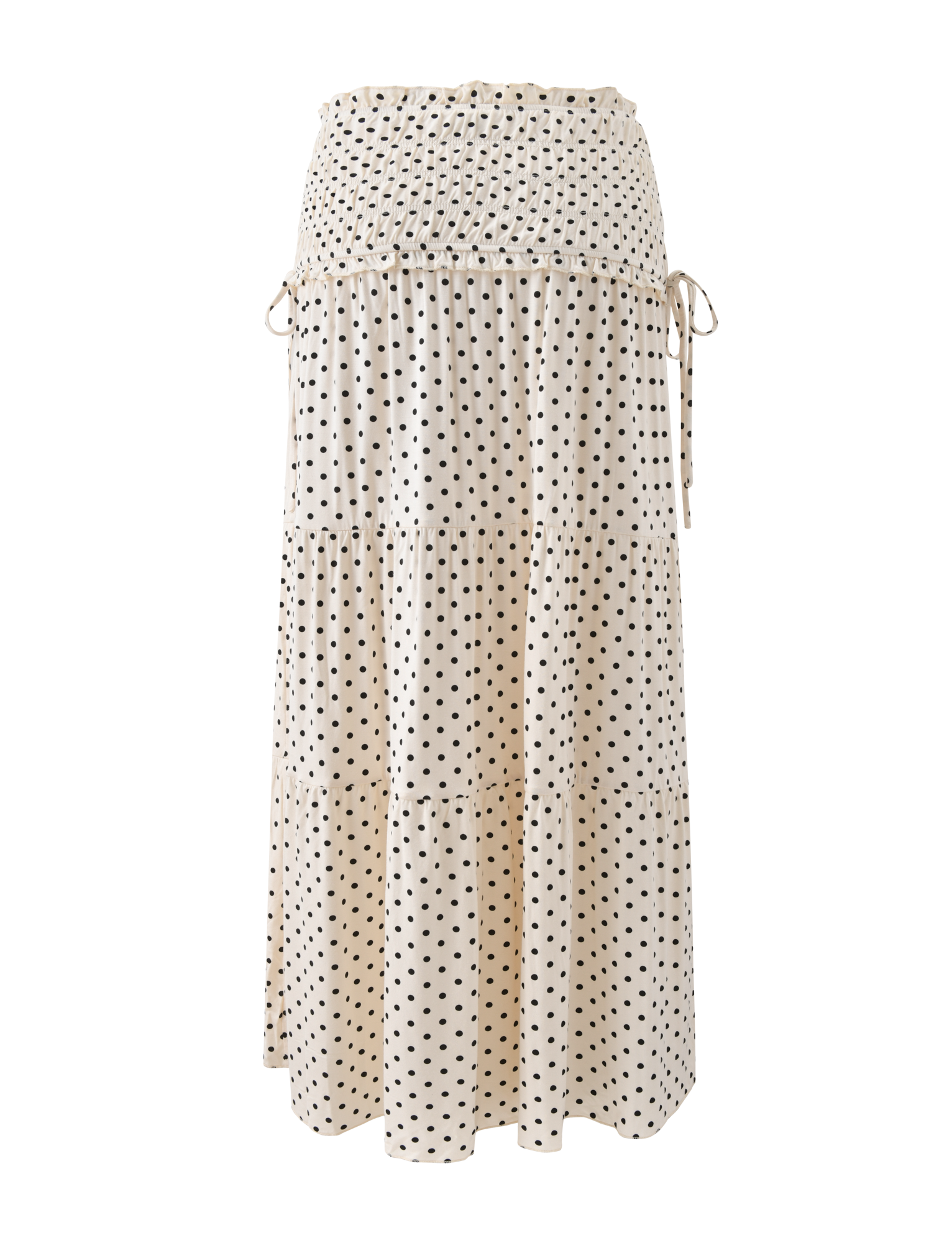 The TIGERMIST DENALI MAXI SKIRT - CREAM DOT is a long, cream polka dot skirt with a smocked waistband, tiered design, side ties, and soft modal fabric, shown against a white background.