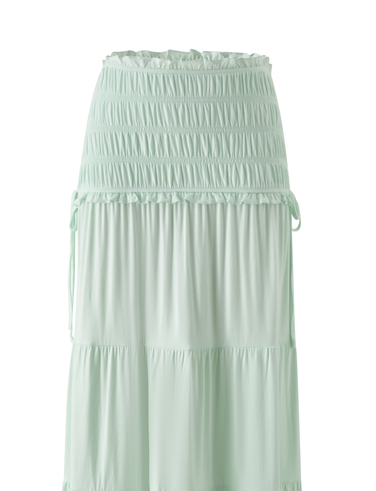 The TIGERMIST DENALI MAXI SKIRT in Soft Mint features a wide shirred elastic waistband, soft modal fabric, subtle ruffle tiers, and side drawstrings for an effortlessly flowy style.