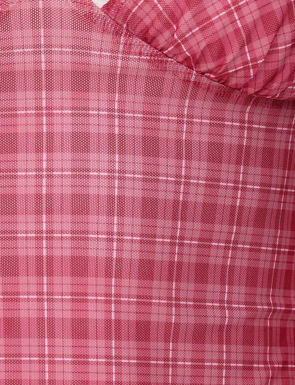 This close-up depicts a pink plaid fabric with a texture akin to the AMARAN TOP - RED by TIGERMIST. The pattern includes white lines forming squares, creating a textured and slightly wrinkled appearance similar to red check print designs.