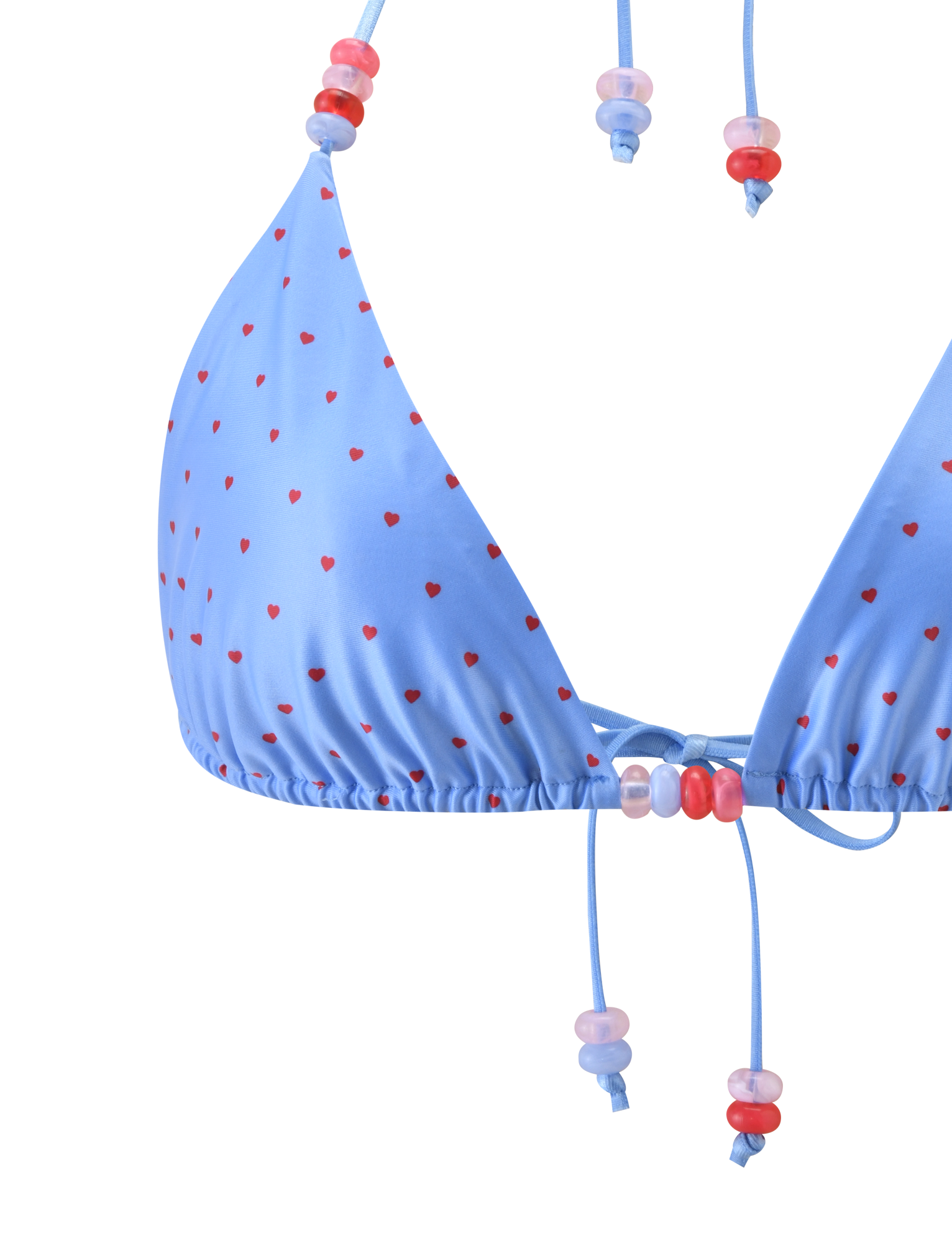 Close-up of the FINLEA BIKINI TOP - BLUE HEART POLKA DOT by TIGERMIST, a light blue triangle bikini top with red heart polka dots and adjustable halter neck strings decorated with pink, red, and purple beads. Plain white background.