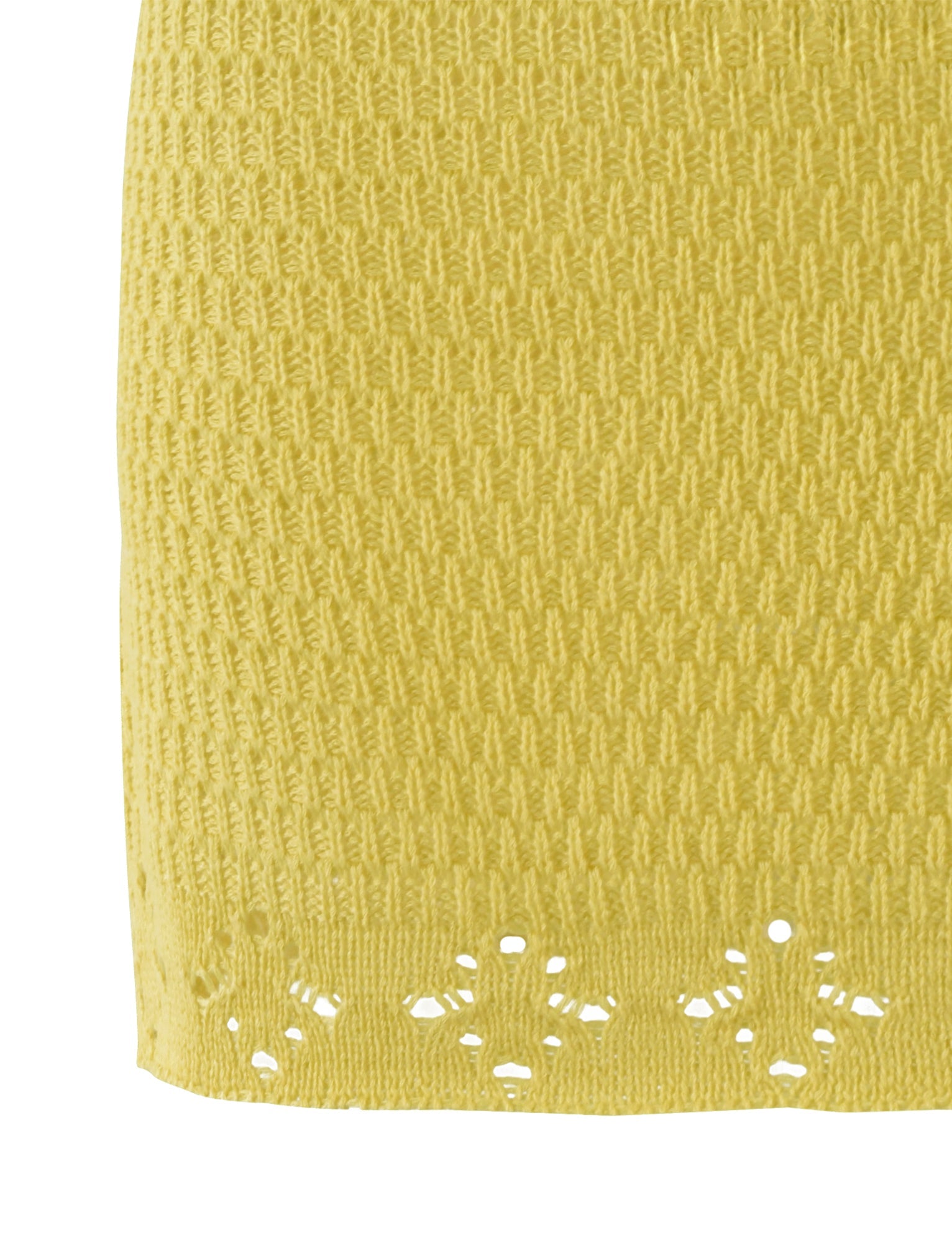A close-up of the JANAI SKIRT - YELLOW : LEMON from TIGERMIST reveals a yellow knitted fabric with a textured zigzag-like pattern, demonstrating uniformity across its surface. The lower section is adorned with delicate openwork flower designs along the edge, highlighting the intricate craftsmanship that TIGERMIST is known for.