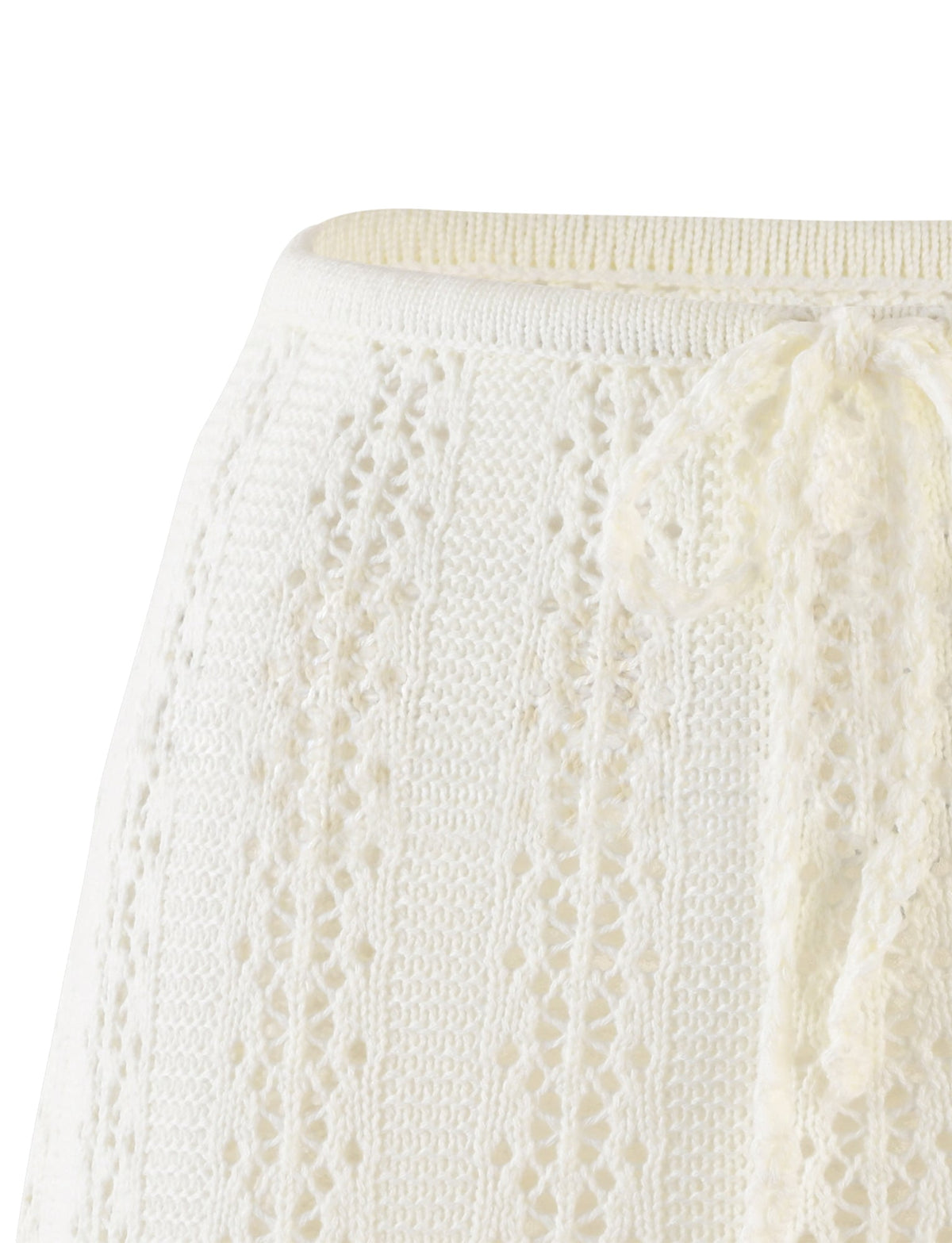 Close-up of the SANDOR SKIRT - WHITE from TIGERMIST showcasing its intricately knit design with small holes and a decorative yarn bow at the waistband. The texture appears soft and detailed, featuring a ribbed edge at the top.