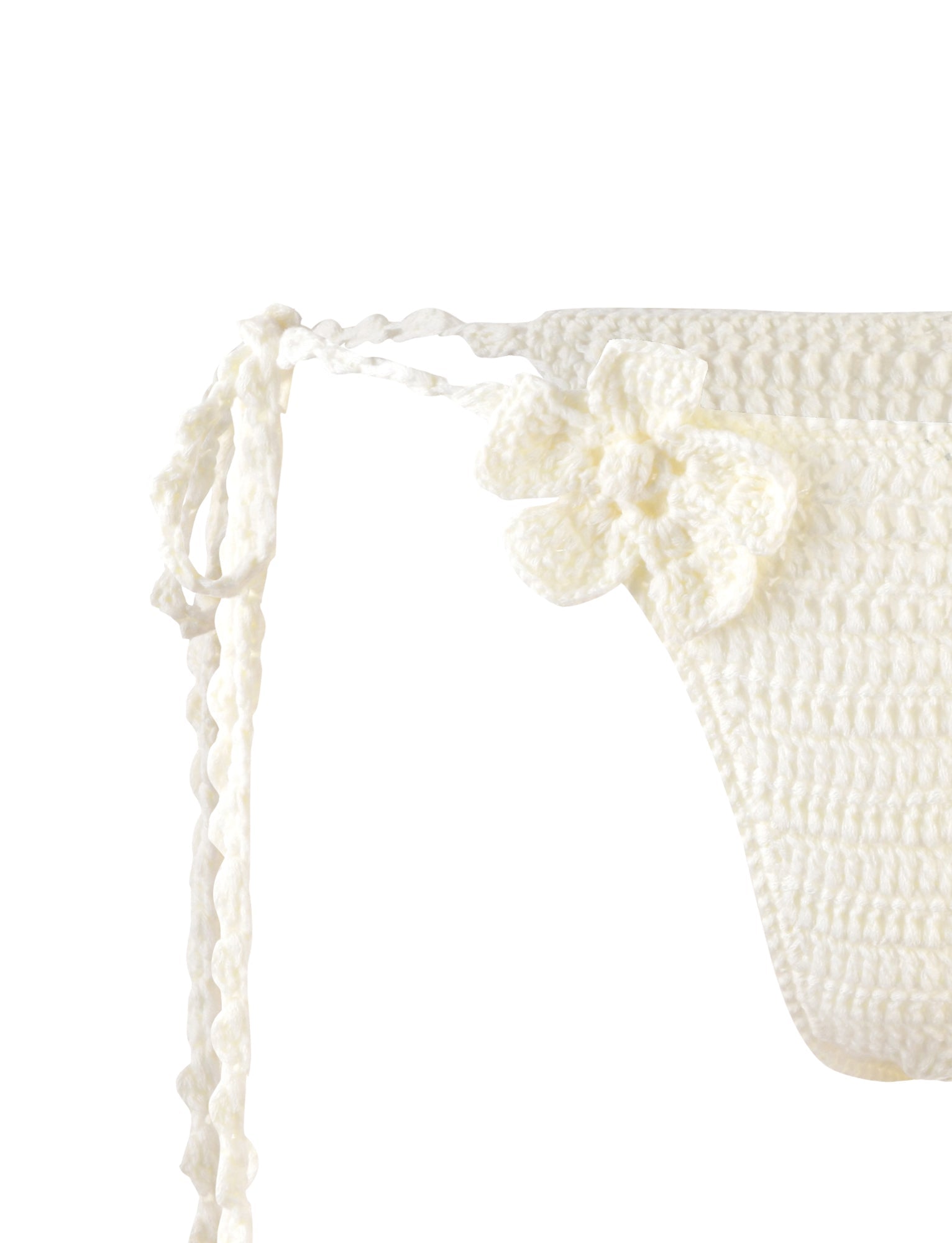 Close-up of the MELIORA BIKINI BOTTOM - WHITE from TIGERMIST, featuring tie strings on the side and a small crocheted flower embellishment near the waistband. The intricate stitching and detail of the crochet texture are clearly visible.