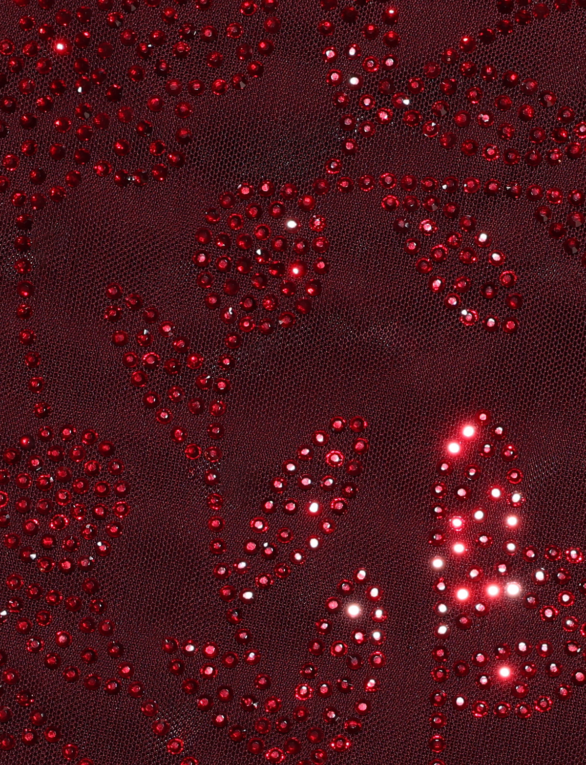 Close-up of the TIGERMIST OCTAVIA DRESS - PURPLE : WINE, featuring sheer burgundy fabric with sparkling red rhinestone floral embellishments for a shiny, elegant look.