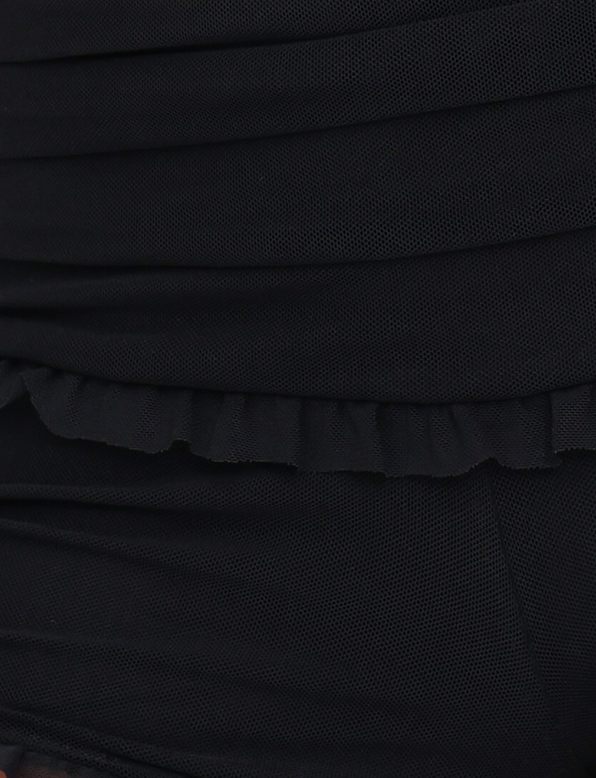 Close-up of the GINNY SHORT - BLACK by TIGERMIST, showcasing black fabric with layered ruching and delicate ruffle details that highlight the bodycon fit of these mini shorts.