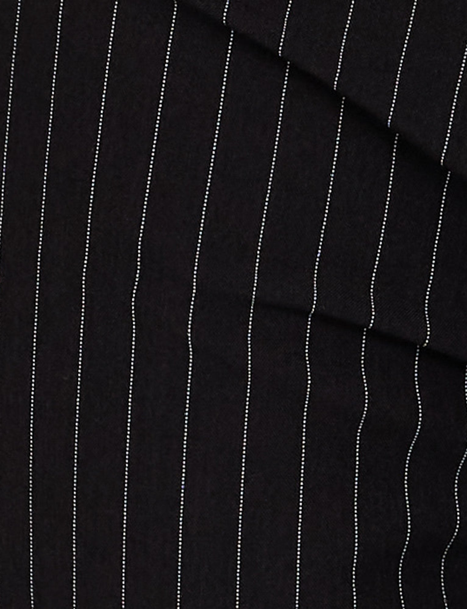 Close-up of the TAMARA PANT - BLACK: PINSTRIPE by TIGERMIST, highlighting the fine vertical lines and soft texture of the fabric. The evenly spaced white pinstripes run parallel to each other, creating a classic and formal pattern typically seen in tailored clothing such as pinstripe suit pants.