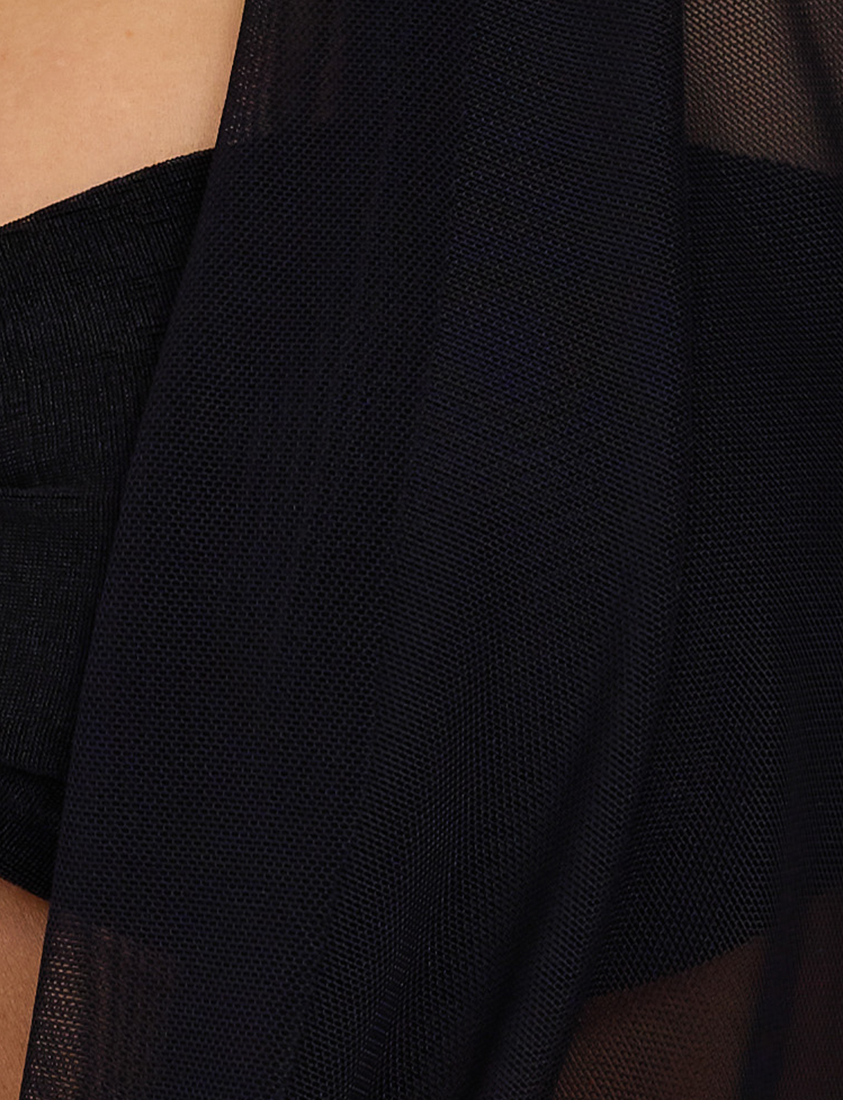 Close-up of the MAKENA TWO-PIECE TOP in black by TIGERMIST, featuring sheer, textured fabric draped over skin and a semi-transparent finish that subtly reveals the surface beneath.