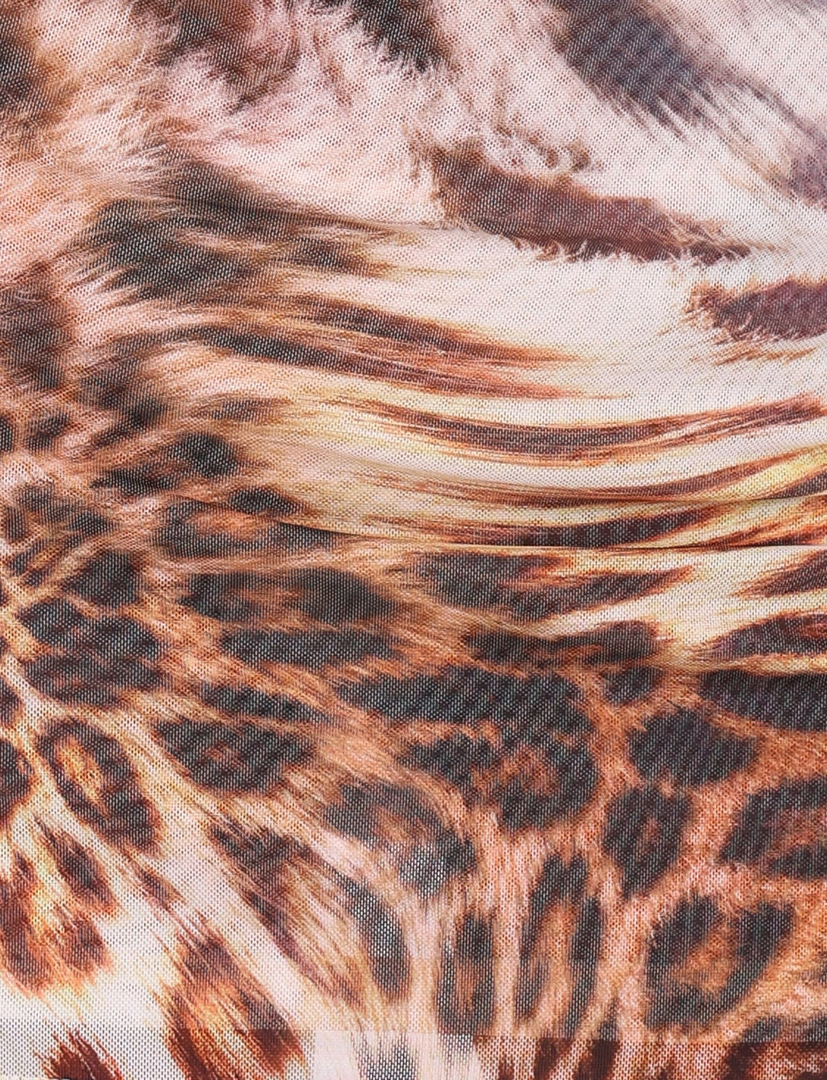 A close-up image of a fabric with an animal print pattern. The KALILAH MINI DRESS - NEUTRAL : LEOPARD HAZE by TIGERMIST features a mix of leopard and tiger prints, incorporating browns, blacks, and tans for a striking and wild appearance. The texture of the fabric appears soft and slightly furry, complemented by adjustable spaghetti straps.