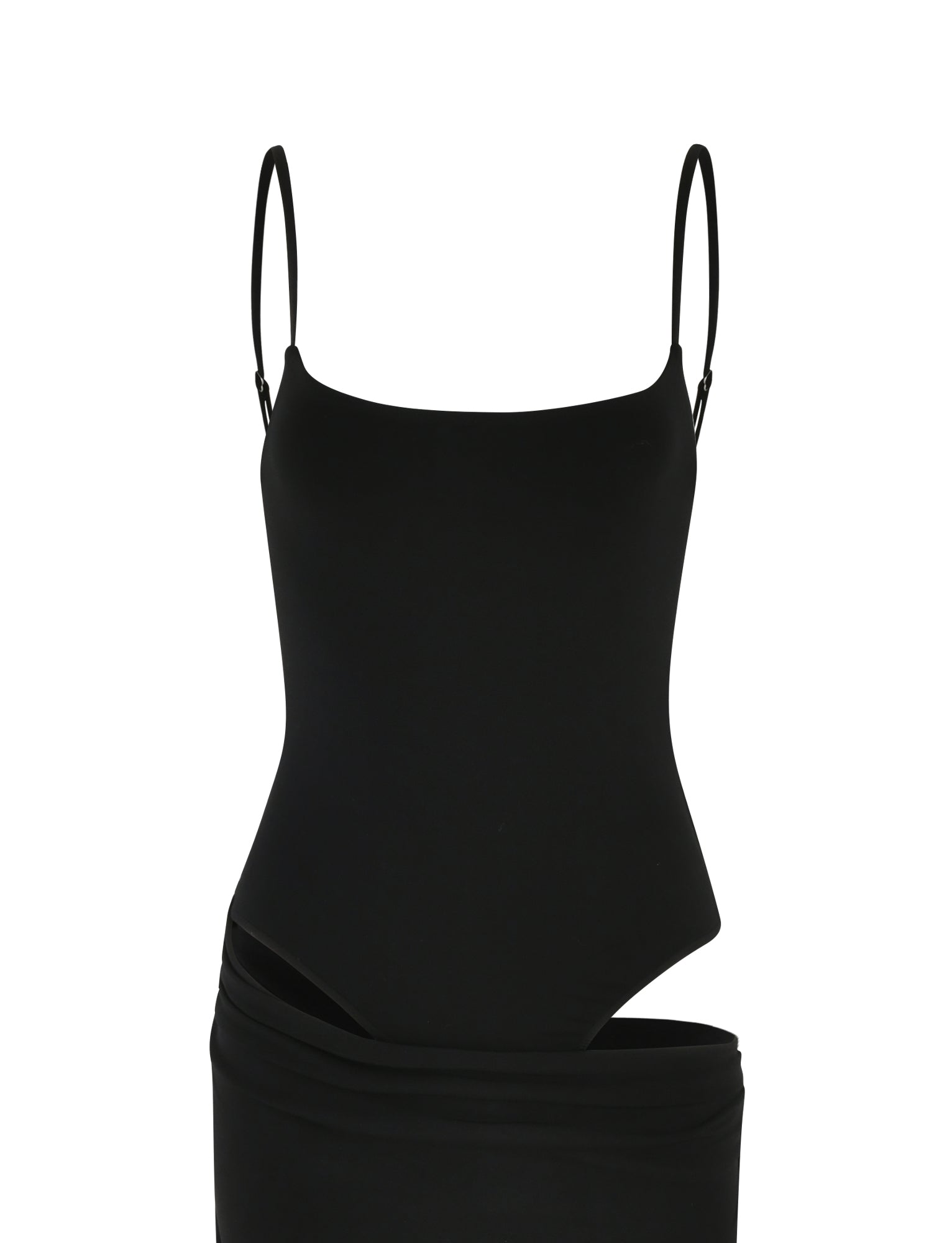 The UMA DRESS - BLACK by TIGERMIST is styled over a black one-piece bodysuit with adjustable straps and a scooped neckline, creating a sleek, layered look against a white background.