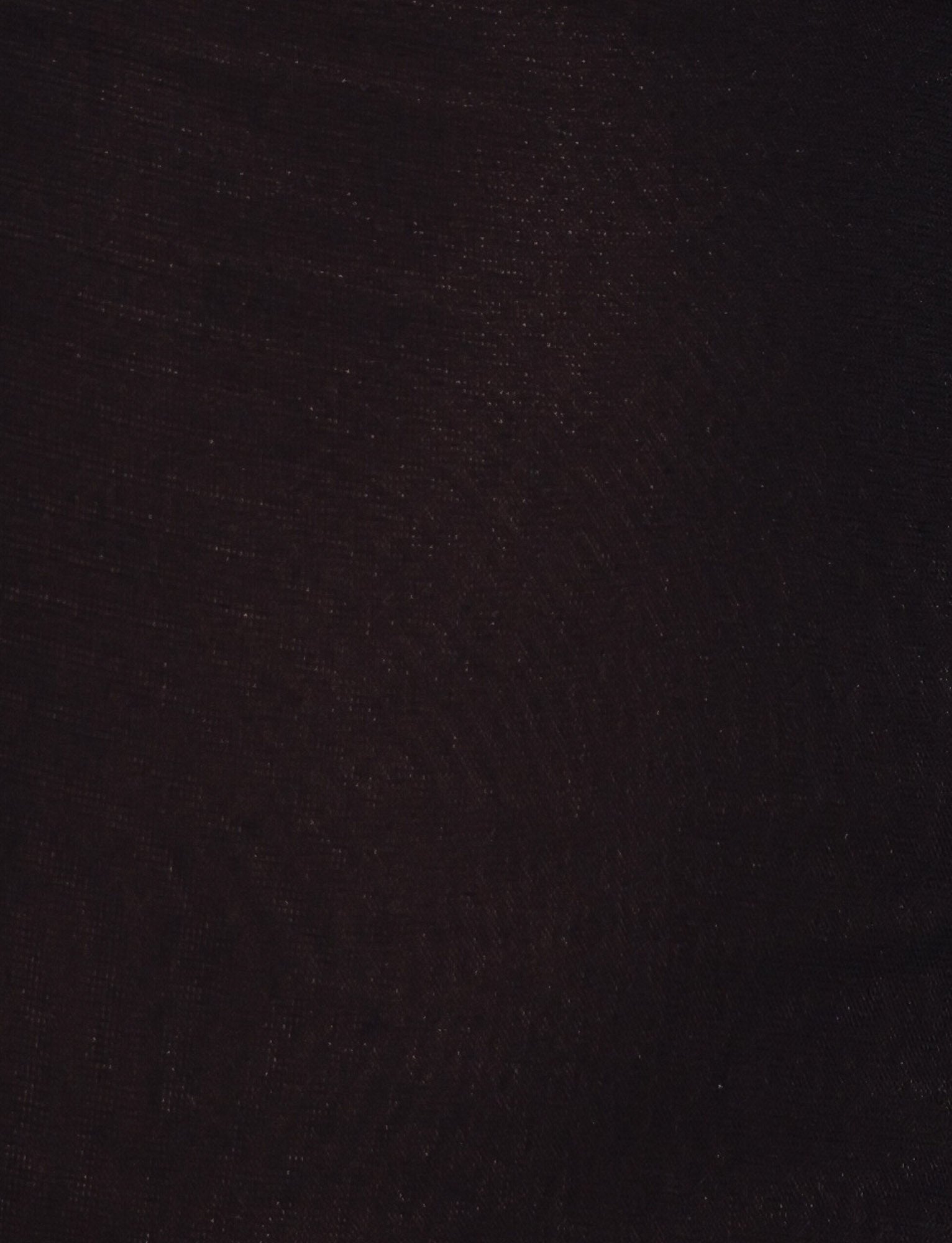A close-up of the textured black fabric from the TIGERMIST FREYA DRESS, featuring subtle fine lines and faint highlights visible under low lighting.