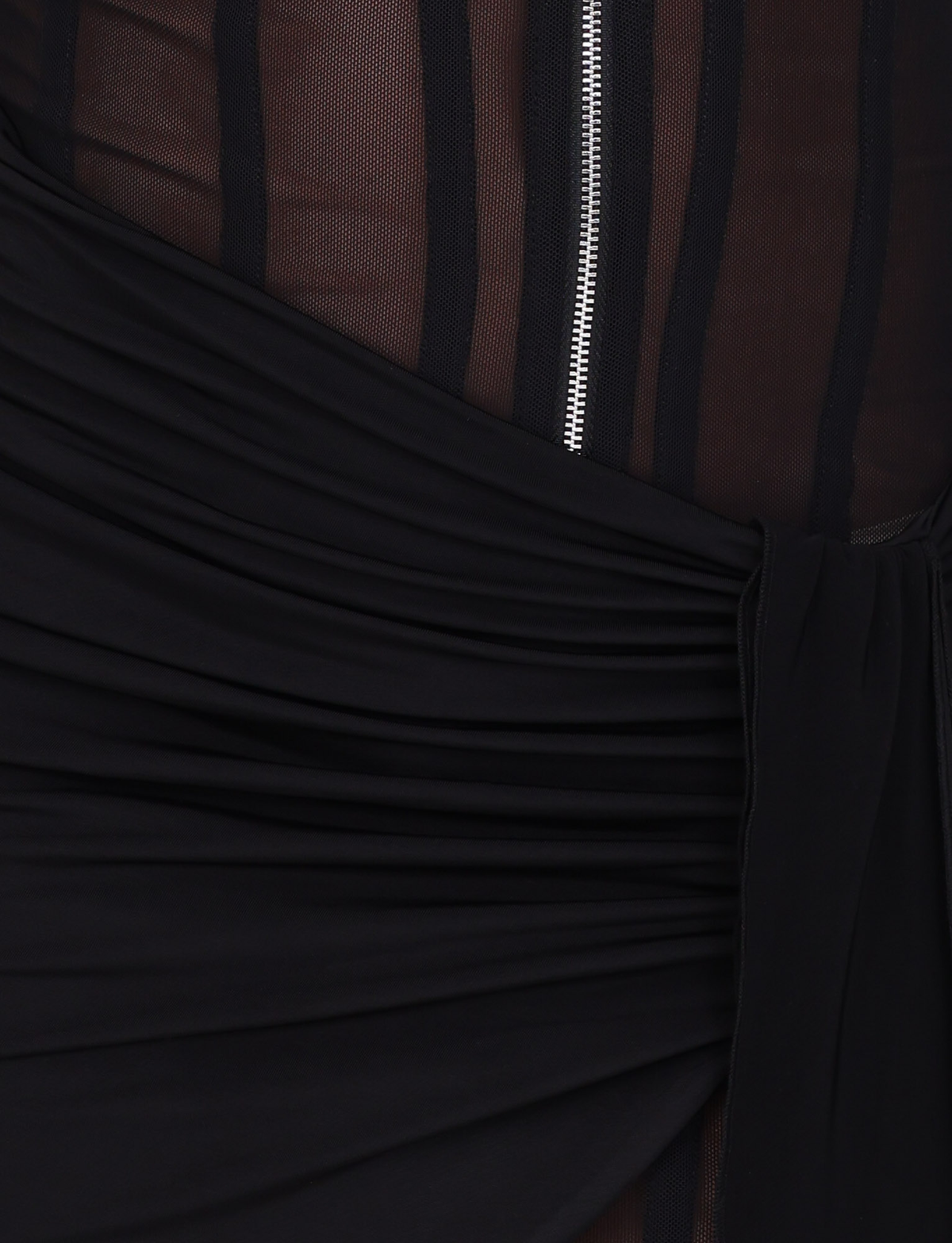 Close-up of the TIGERMIST CATERINA MINI DRESS - BLACK, featuring sheer black mesh with vertical stripes, a visible silver zipper, and ruched draping at the waist in slinky jersey.