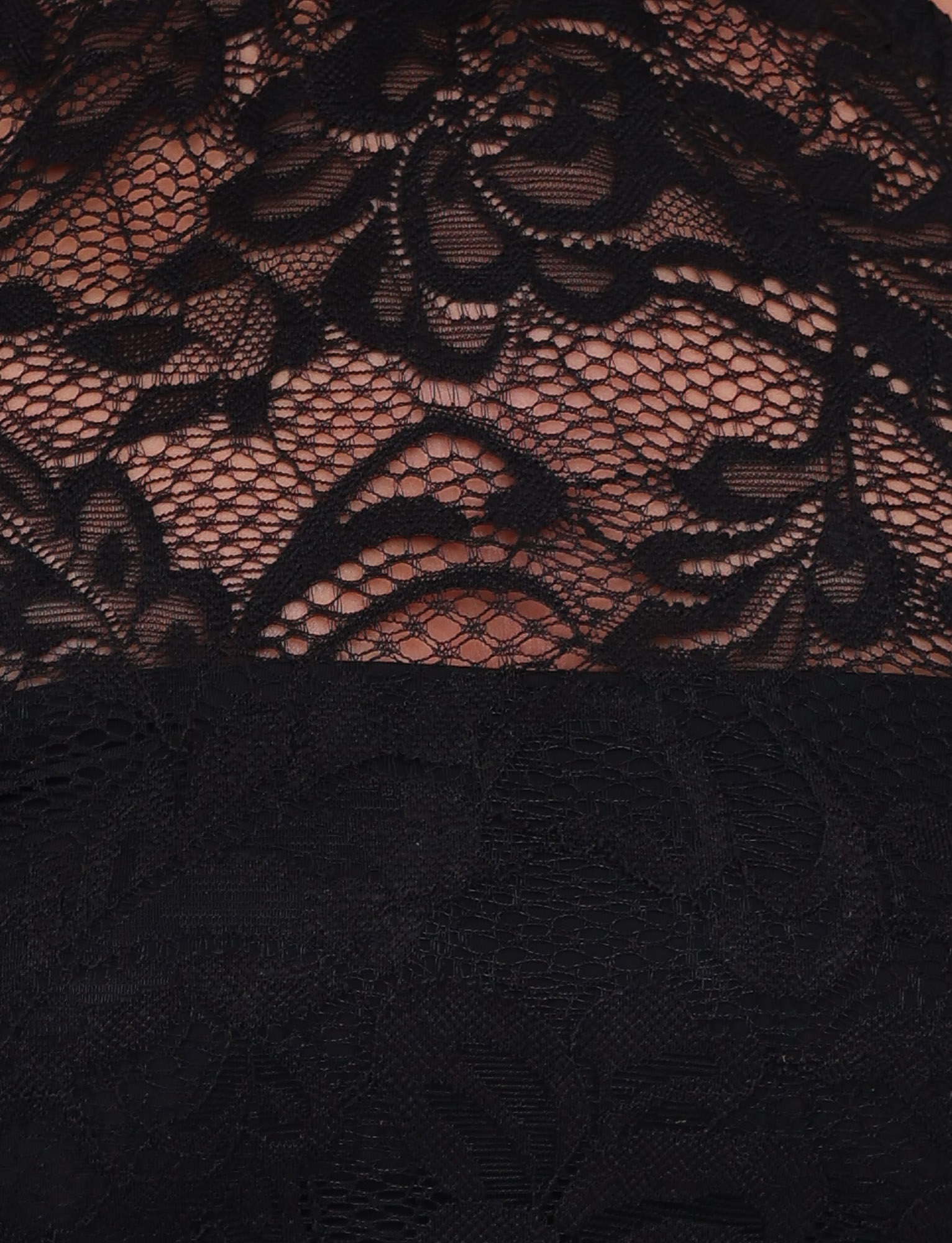 Close-up of the SIYA LACE TOP by TIGERMIST in black, featuring intricate floral lace with leaves and flowers. The design includes a sheer upper section, high neckline, and opaque lower panel.