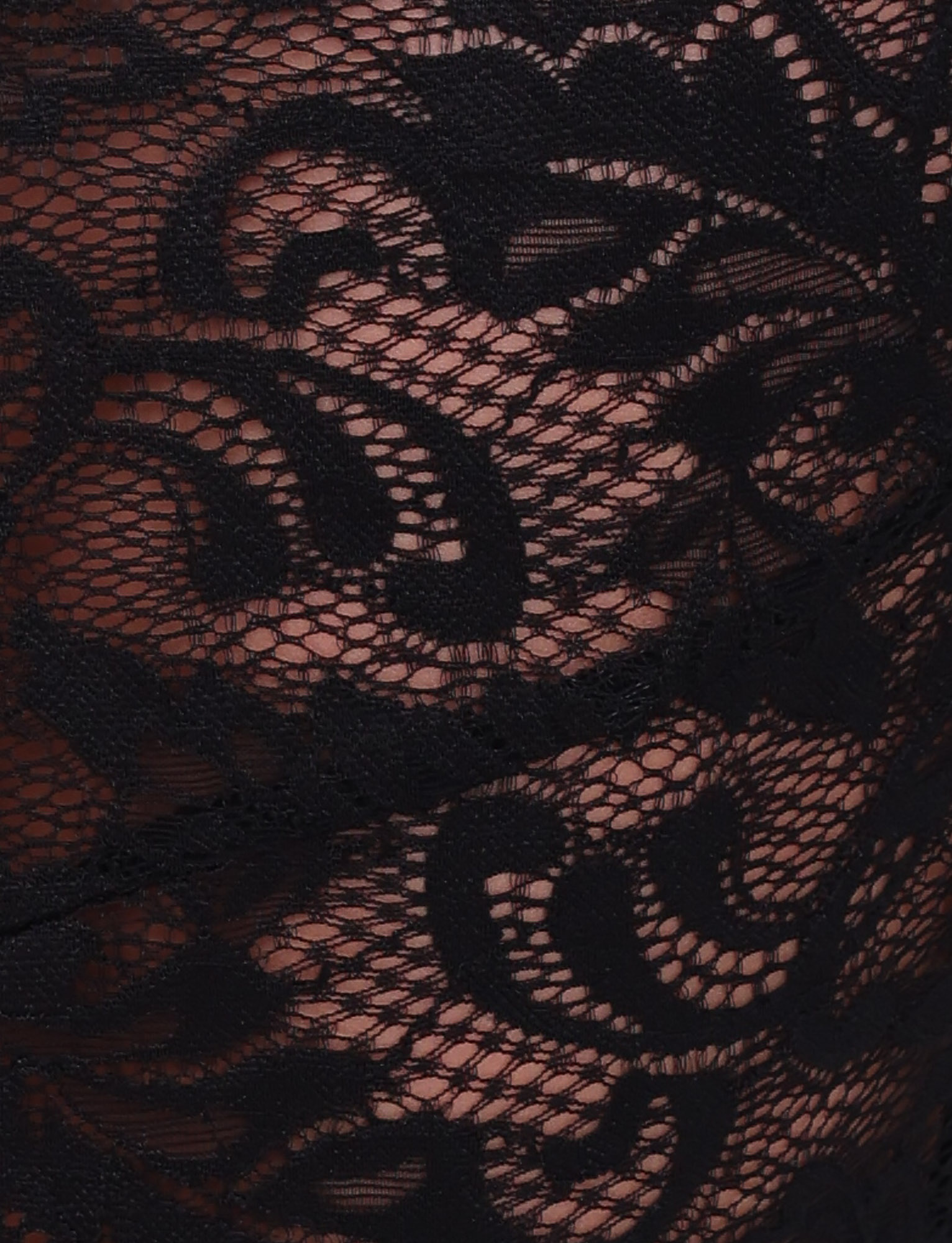 Close-up of the TIGERMIST SIYA MIDI SKIRT in black lace, featuring intricate floral patterns and a sheer design that reveals a layer of skin-toned material underneath.