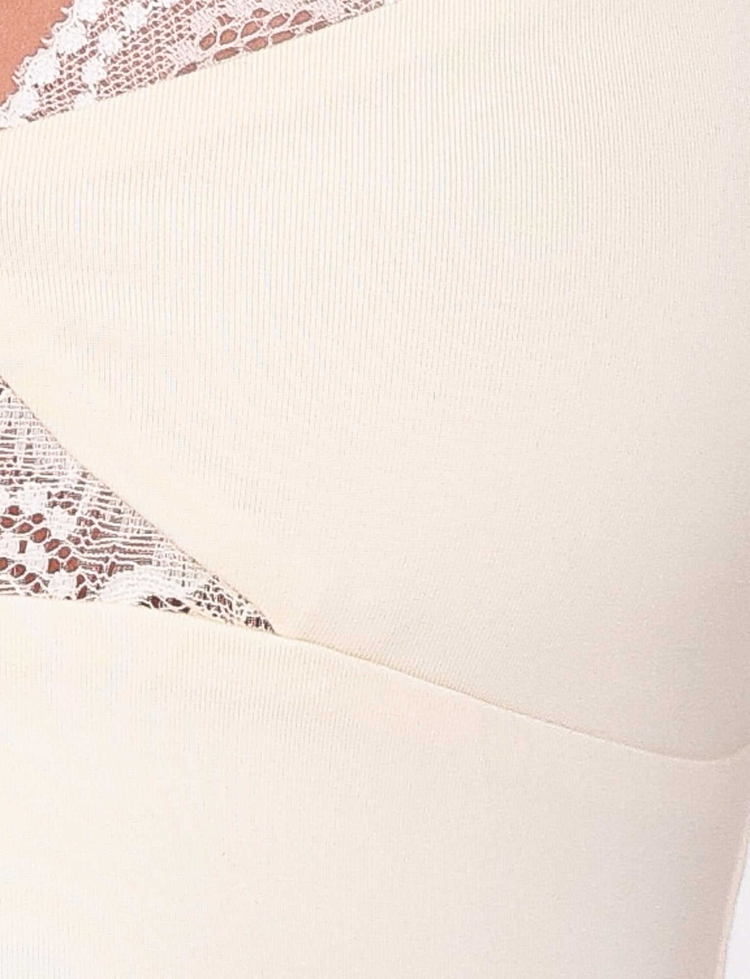 Close-up of the DIONE LACE TOP - SOFT BUTTER by TIGERMIST: a cream-colored jersey top with a V-neck, bodycon fit, and intricate lace trim, offering a delicate contrast to its smooth texture for an elegant look.