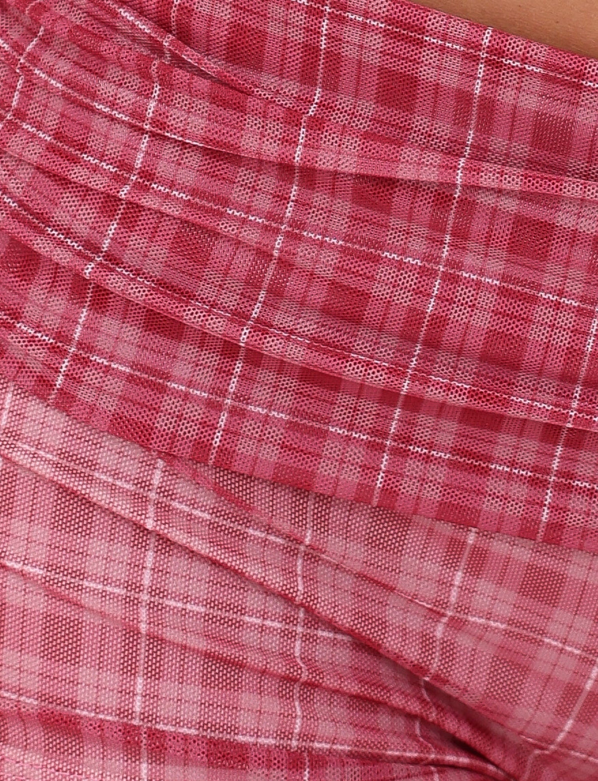 Close-up of the AMARAN SHORT - RED : RED CHECK by TIGERMIST, showcasing a red and white checkered pattern. The fabric is highly stretchy with a textured appearance, gathered in layers for added depth and dimension.