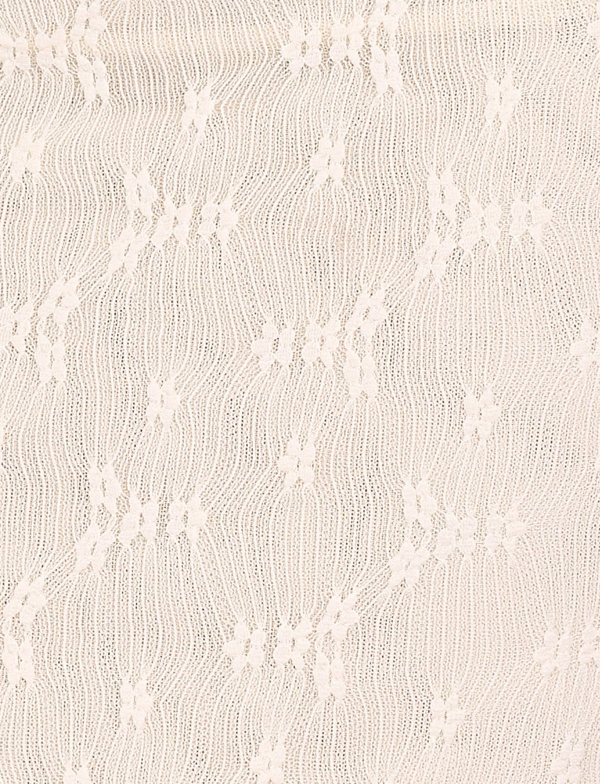 Close-up of the TIGERMIST FIORELLA MINI DRESS - WHITE : LACE : CREAM, highlighting its cream lace fabric with a wavy textured pattern and evenly spaced small floral motifs.