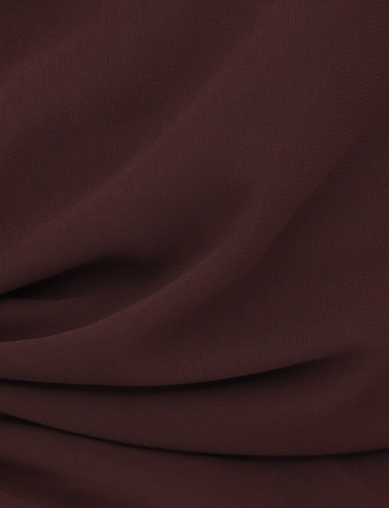 Close-up of the TIGERMIST INDIGO TOP - BROWN : CHOCOLATE shows chocolate brown fabric with soft folds and a textured surface, creating gentle shadows—ideal for a chic and elegant statement piece.