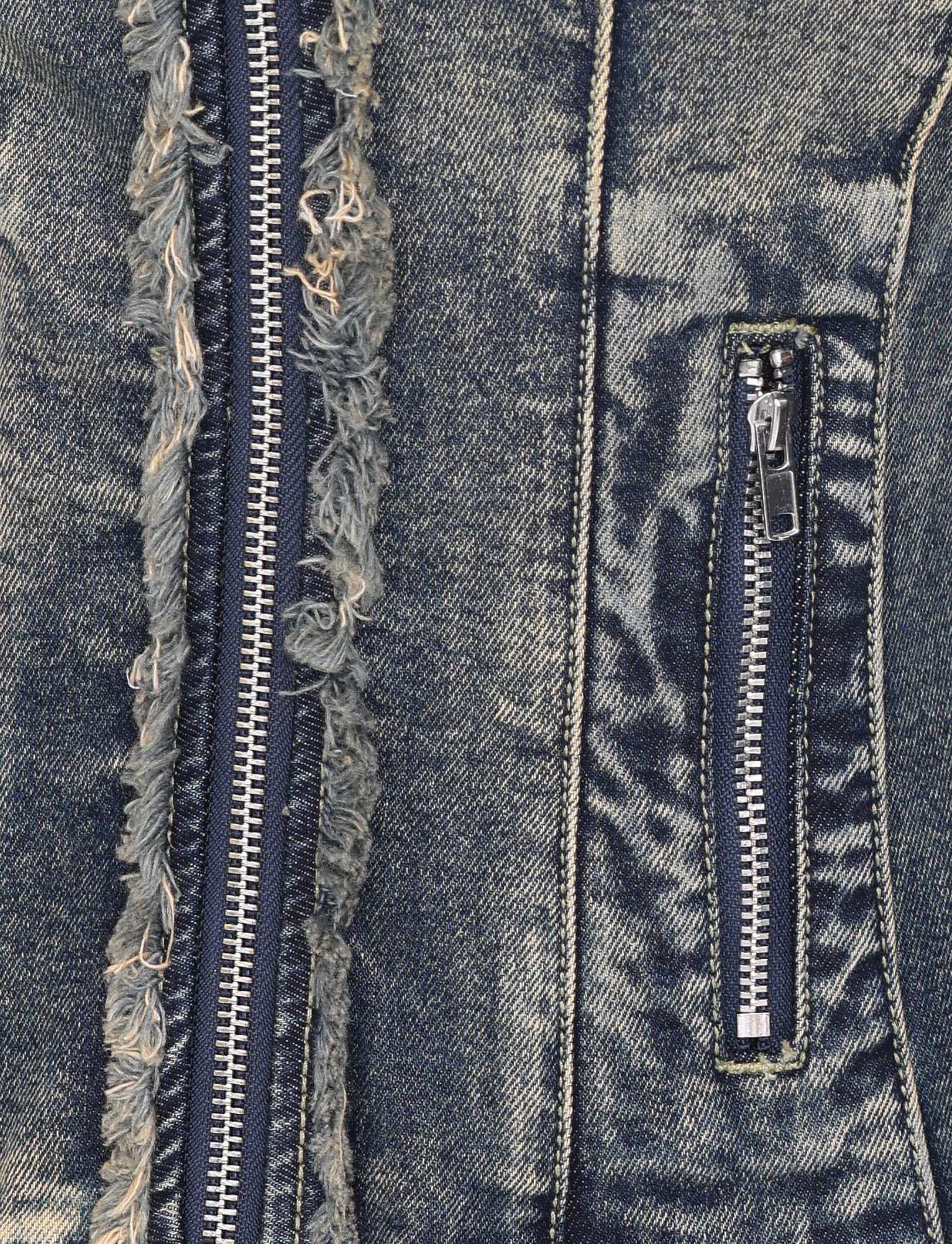 Close-up of the OPHELIE JACKET - BLUE by TIGERMIST, showing vintage wash denim fabric with a frayed seam, large vertical zipper, and small zippered pocket on the right—ideal for a fitted or moto jacket style.