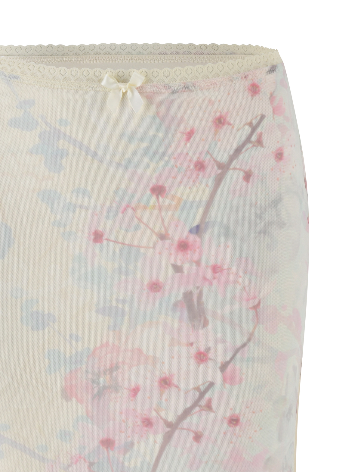 Close-up of the TIGERMIST LONIE MIDI SKIRT in Neutral: Floral: Washed Cherry Blossom—a sheer mesh midi skirt featuring a delicate pink and blue floral print, ivory bow detail, and lace trim along the top edge.
