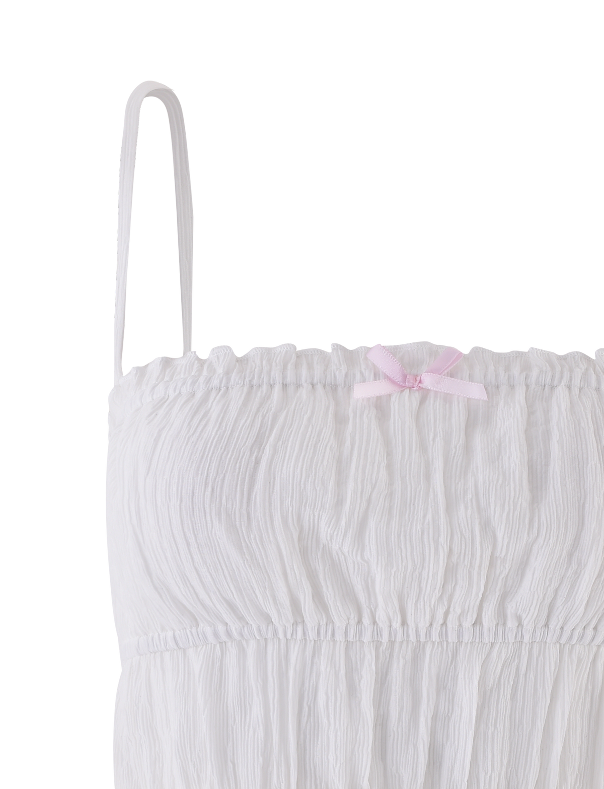 Close-up of the ASHLYNN TOP in white by TIGERMIST, featuring textured fabric, a gathered bust, adjustable spaghetti straps, and a pale pink satin bow at the neckline. Only the upper left section is shown.