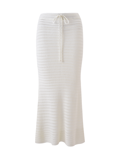 The EMELYN MIDI SKIRT in cream by TIGERMIST is a long, white, semi-sheer crochet midi skirt with a flared hem and elasticated waist, shown on a plain white background.