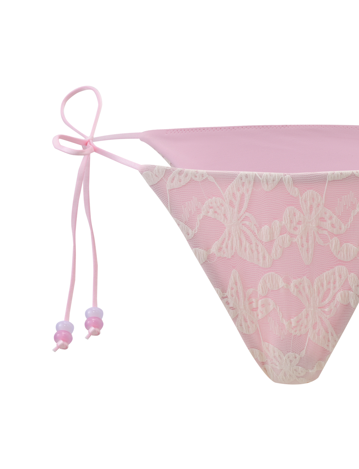 A close-up of the TIGERMIST BRIGITTE BIKINI BOTTOM in ivory lace, featuring a cheeky fit with thin side ties and delicate lace overlay, shown against a light background.