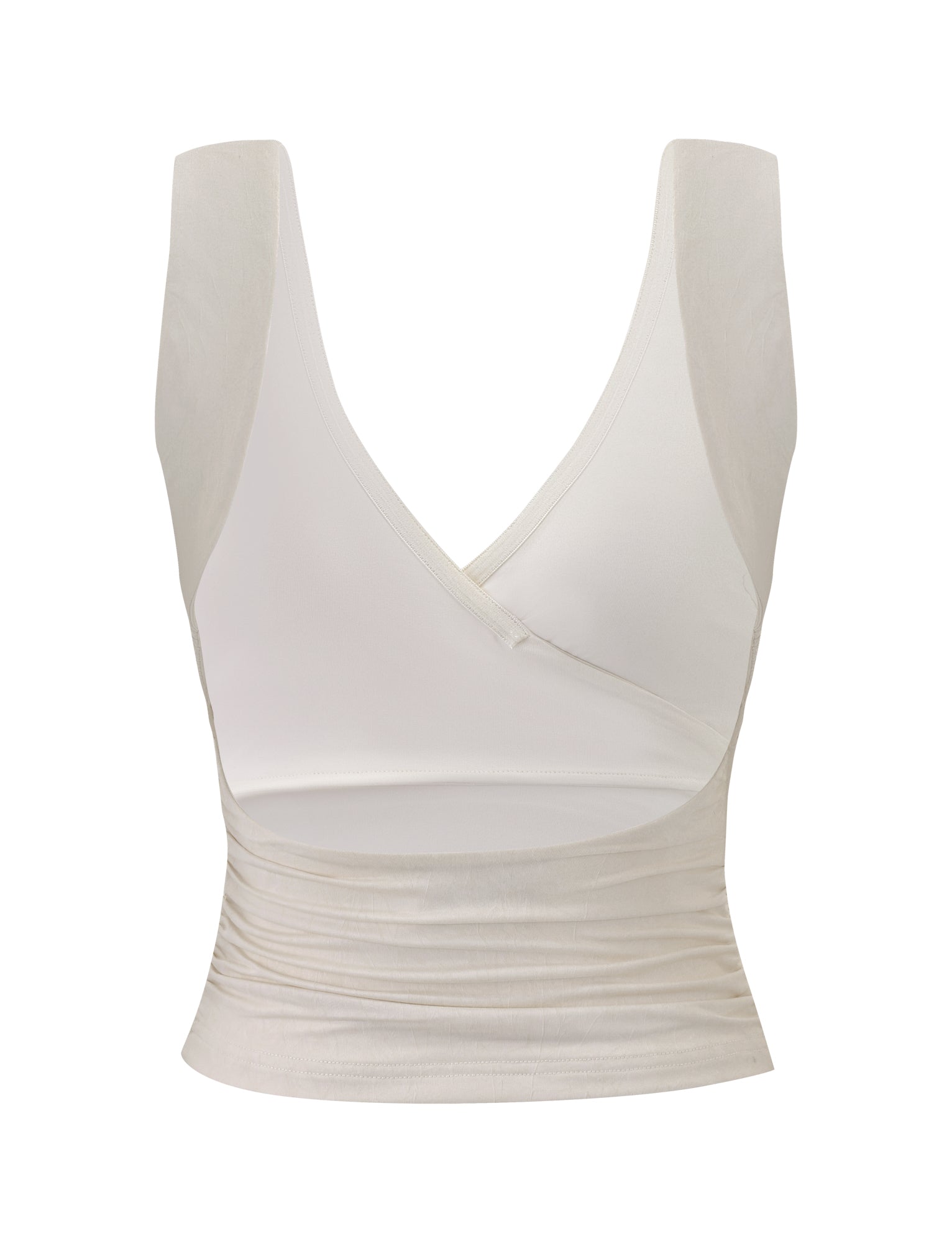 The NURA TOP - IVORY by TIGERMIST is a sleeveless, light beige top with a crossover deep V-neckline, gathered details, ruched fitted waistband, and soft, slightly sheer fabric.