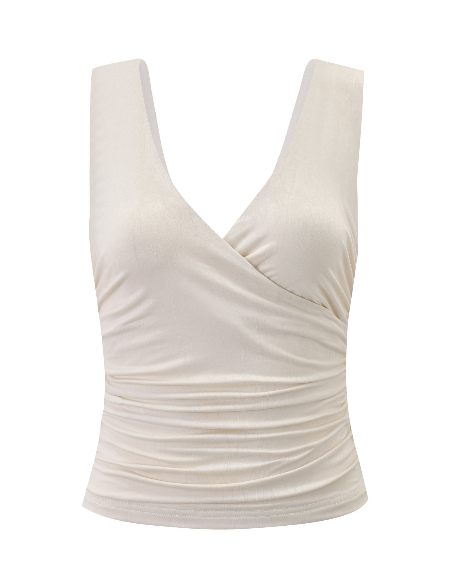 The NURA TOP - IVORY by TIGERMIST features a deep V-neck, crossover neckline, and wrap-style front with slight side ruching to flatter the waist. Its sleeveless design adds an elegant touch.