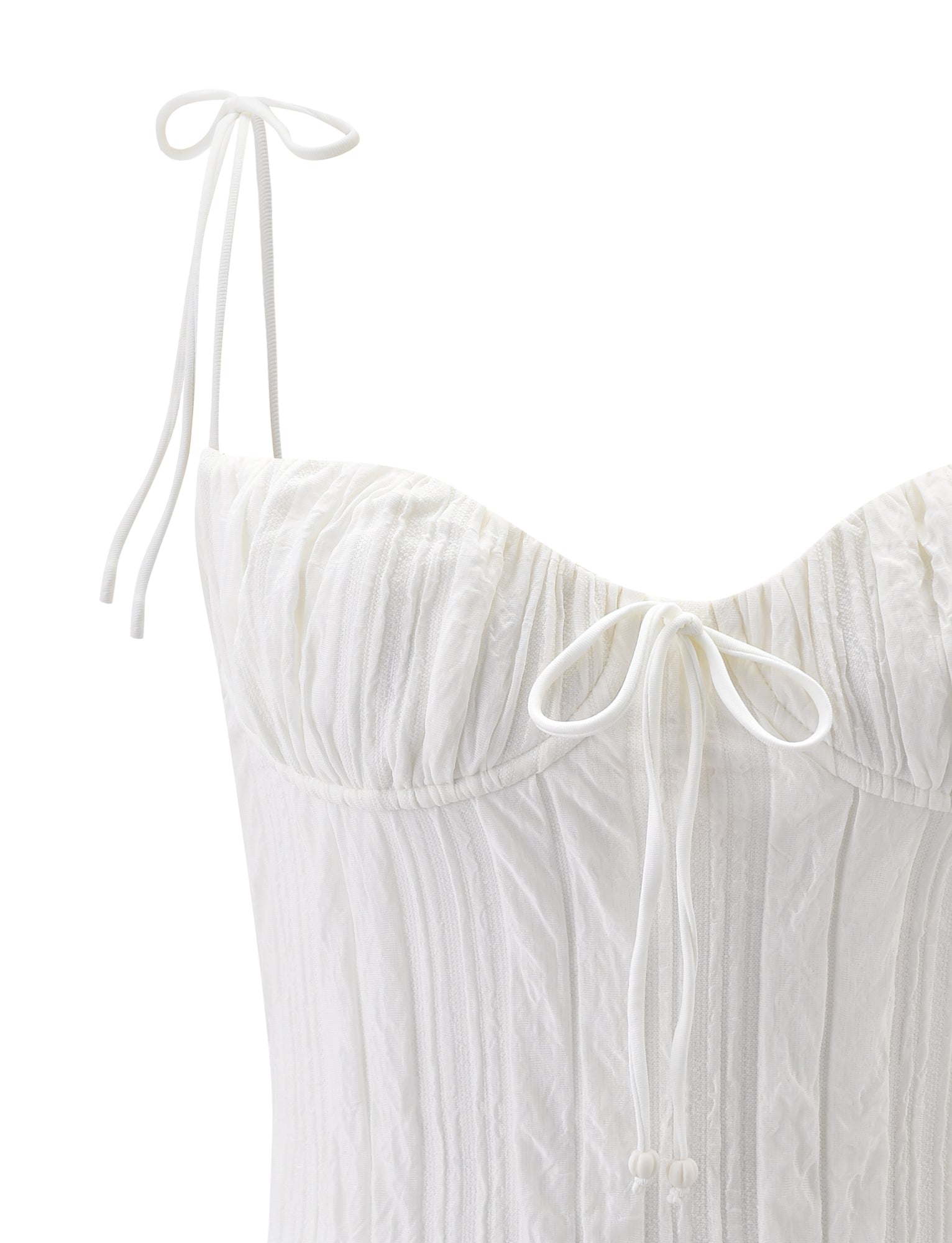 Close-up of the RANIA TOP in off white by TIGERMIST, featuring a textured, corset-style bodice with strappy shoulder straps and a bow accent at the center of the sweetheart neckline.