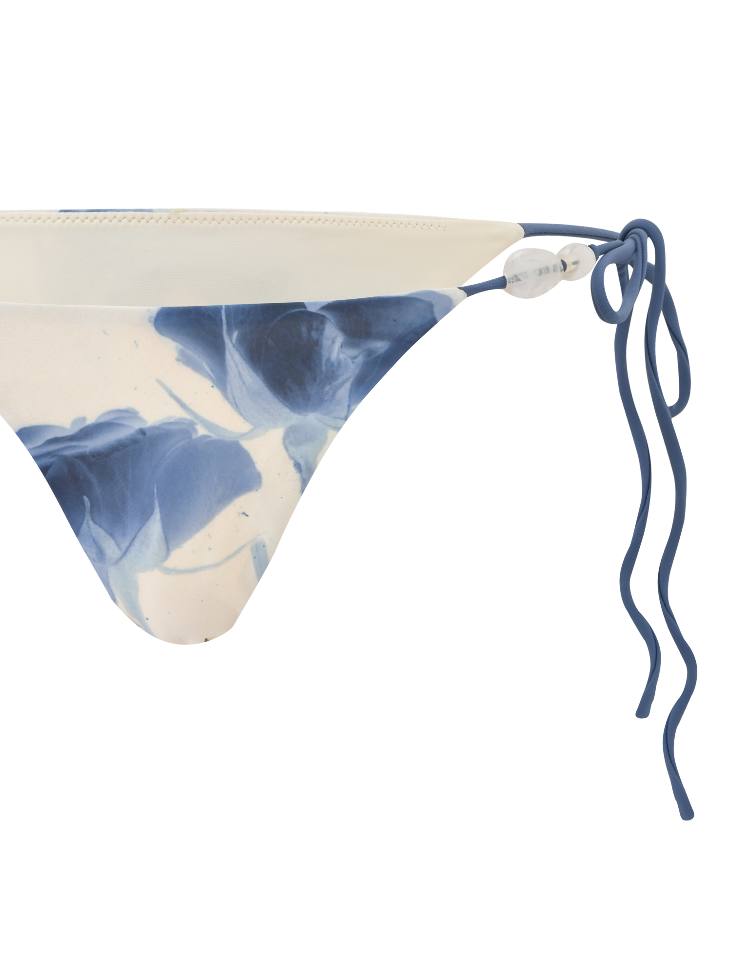 The CYLAS BIKINI BOTTOM - INDIGO FLORAL by TIGERMIST features a blue and white floral pattern, displayed from a side angle on a white background.