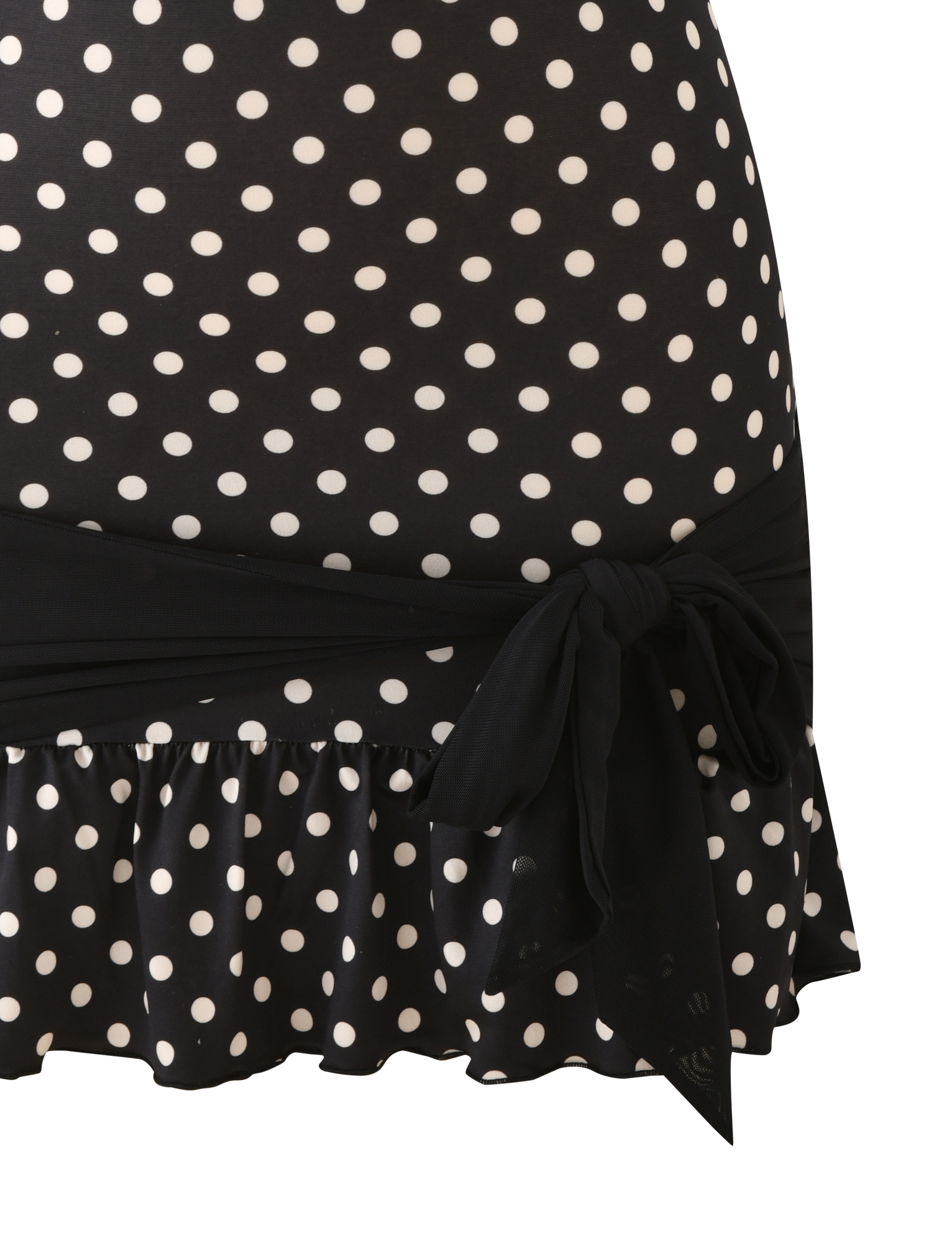 A close-up of the TOVE MINI DRESS - BLACK POLKA DOT by TIGERMIST, featuring white polka dots, a ruffle hem, and a black tie at the waist for a playful touch on the bodycon silhouette.